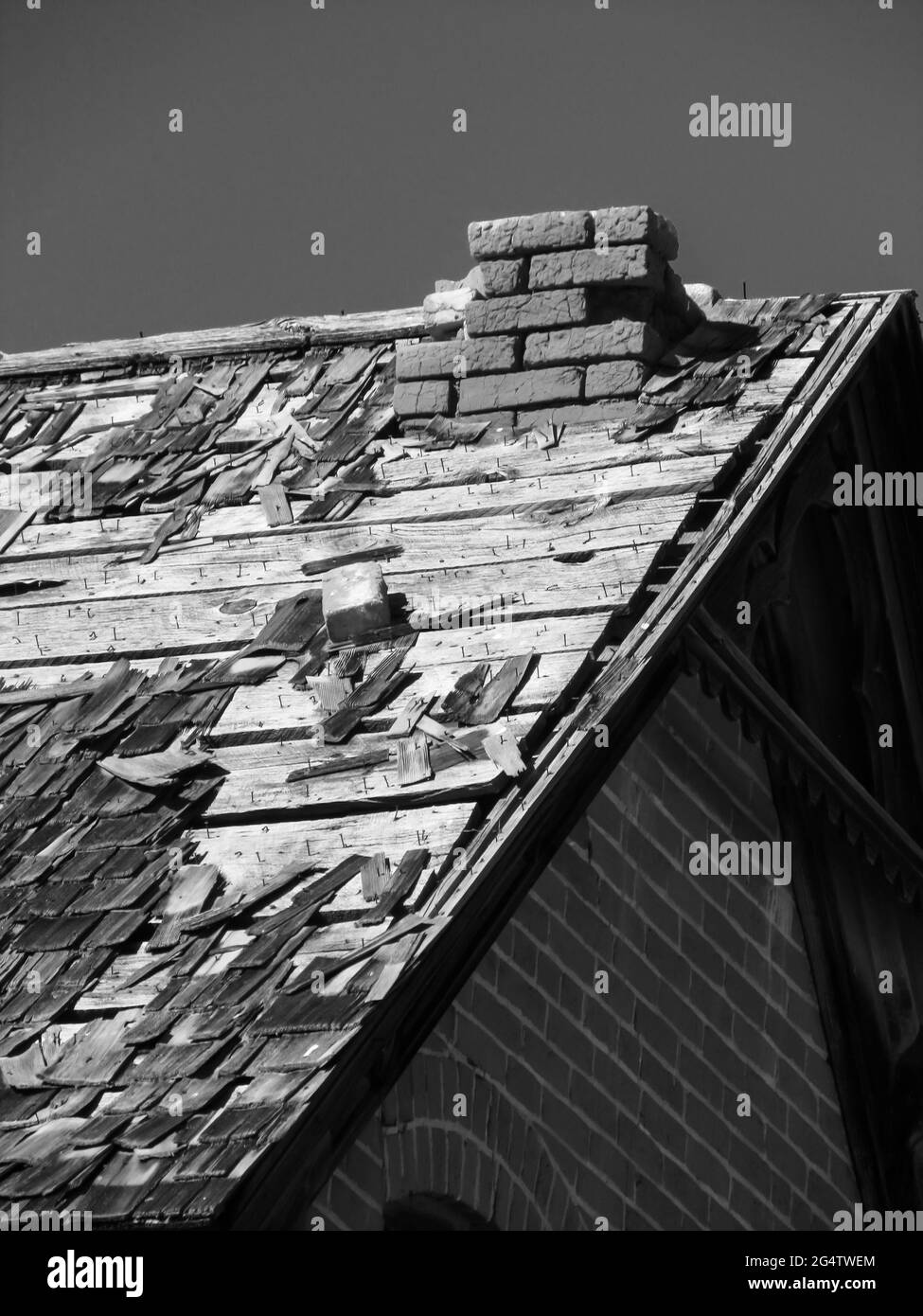 Ein altes, heruntergekommenes Dach, das an einem klaren, sonnigen Tag in der Kleinstadt Escalante, Utah, USA, in Schwarz-Weiß fotografiert wurde Stockfoto