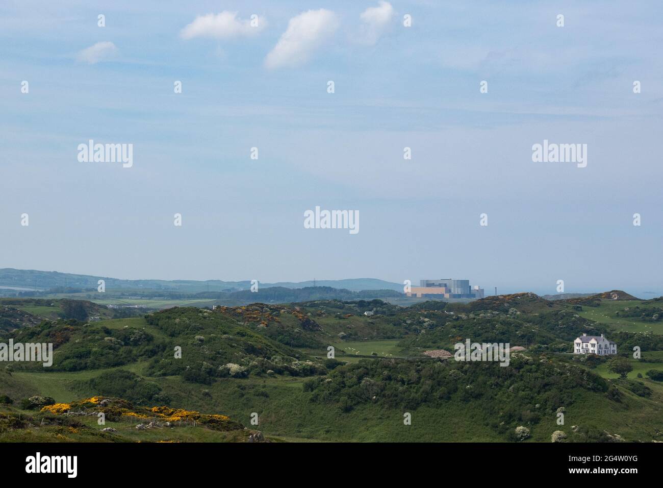 Das stillgelegte Kernkraftwerk Magnox in Wylfa in der Ferne gesehen, während Sie den Isle of Anglesey Coastal Path von der Cemaes Bay aus erkunden. Stockfoto