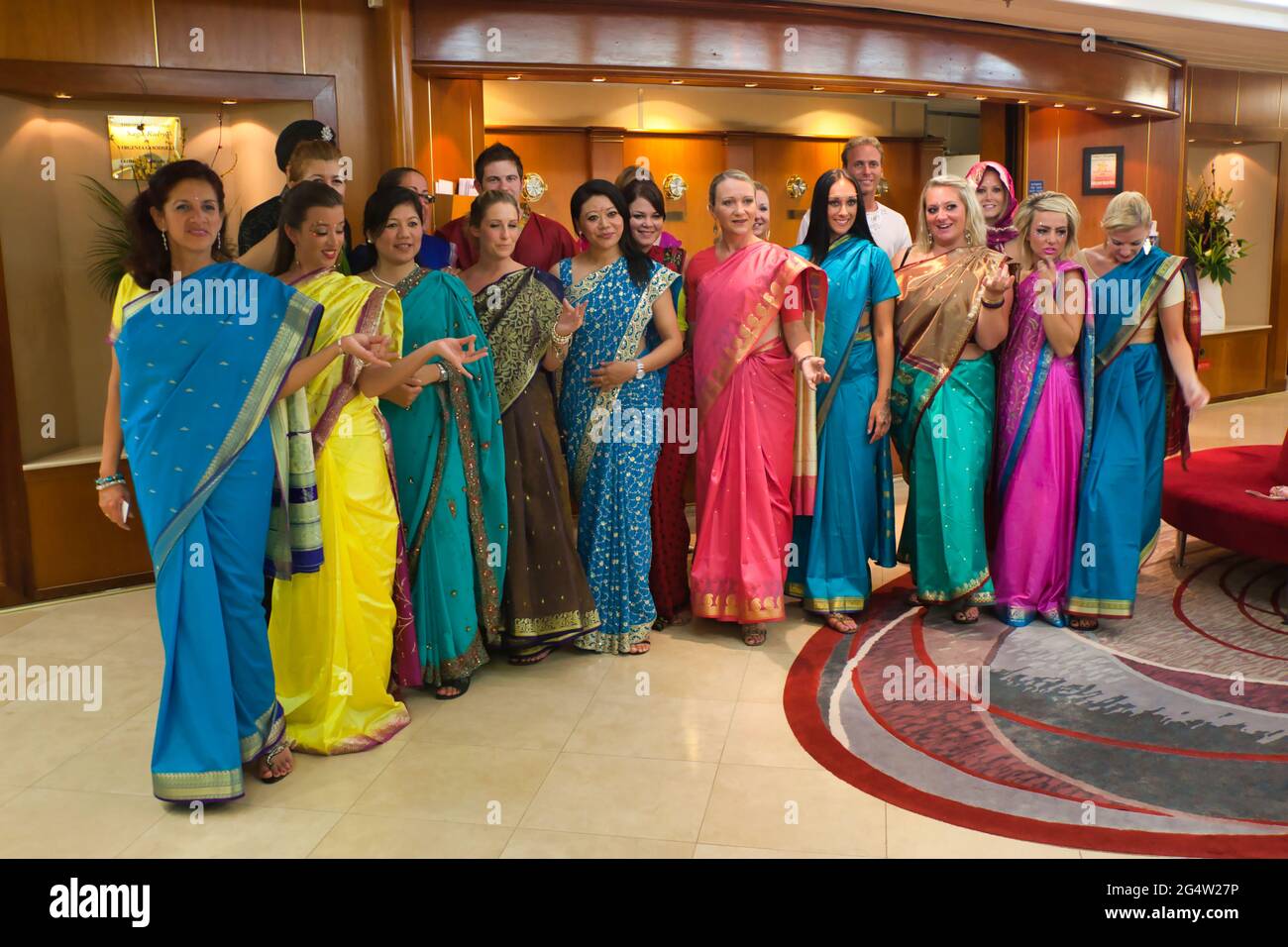 Eine Gruppe eleganter Damen kleidete sich alle in verschiedenen Farben als Saris für eine indische Nacht an Bord eines Kreuzfahrtschiffs Stockfoto