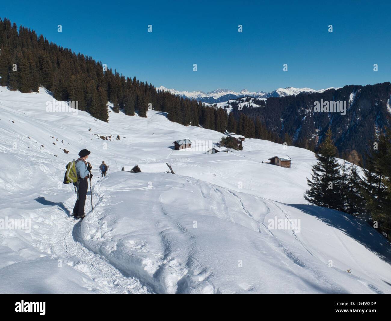 Eine Schneeschuhwandererin hält inne, um sich die Aussicht auf das Safiental im Kanton Graubünden in den Schweizer Alpen, Schweiz, anzusehen Stockfoto