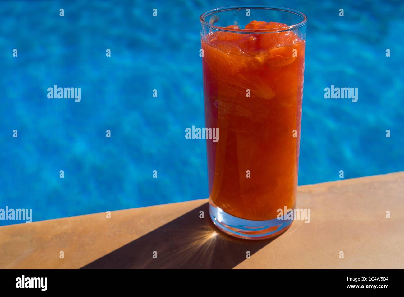 Frisches Fruchtgetränk aus Kaki in der mediterranen Sommersonne am Pool Stockfoto