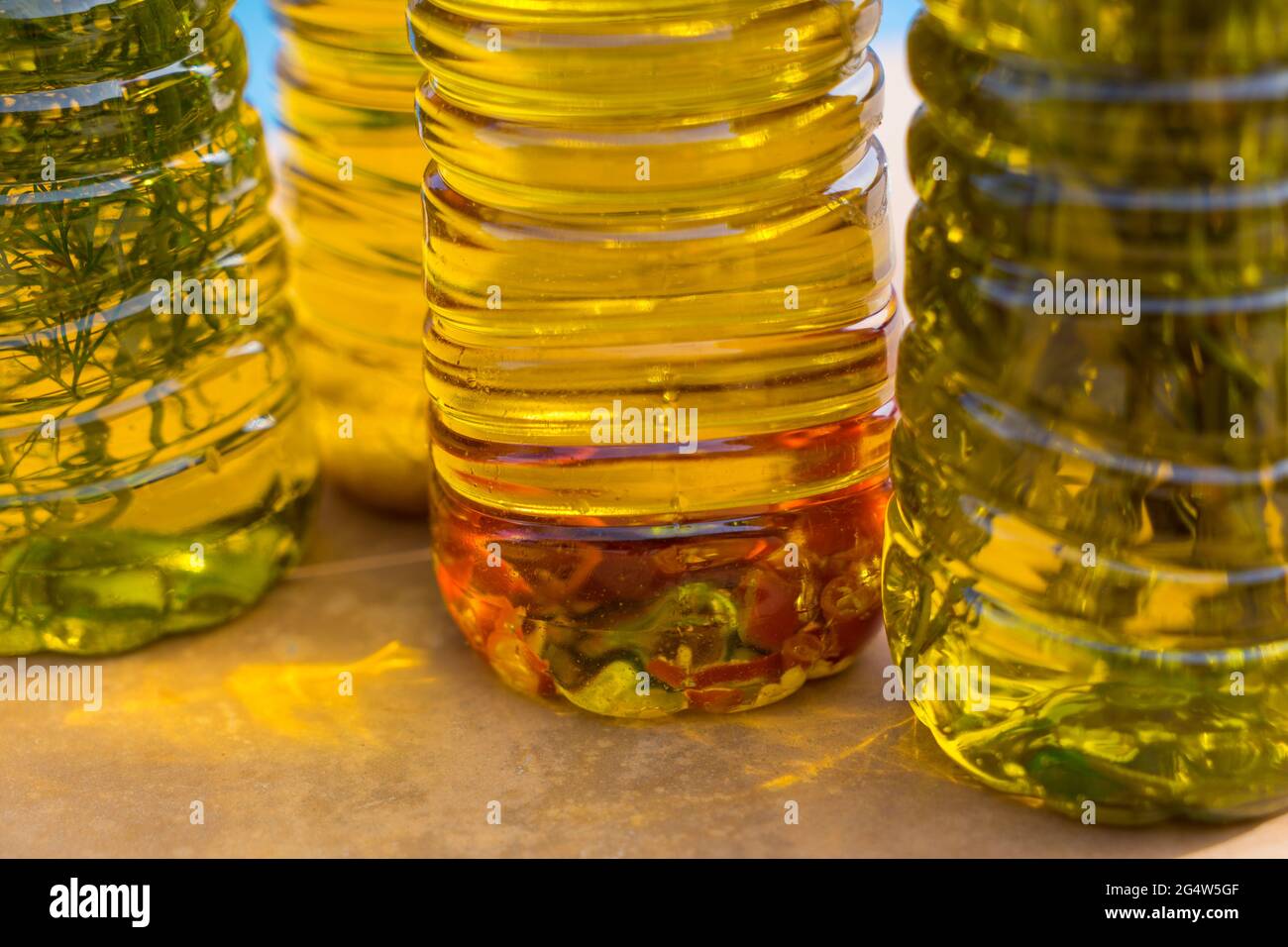 Eine Reihe von aromatischen goldenen Olivenölen, angereichert mit würzigem Chili und mediterranen Kräutern Stockfoto