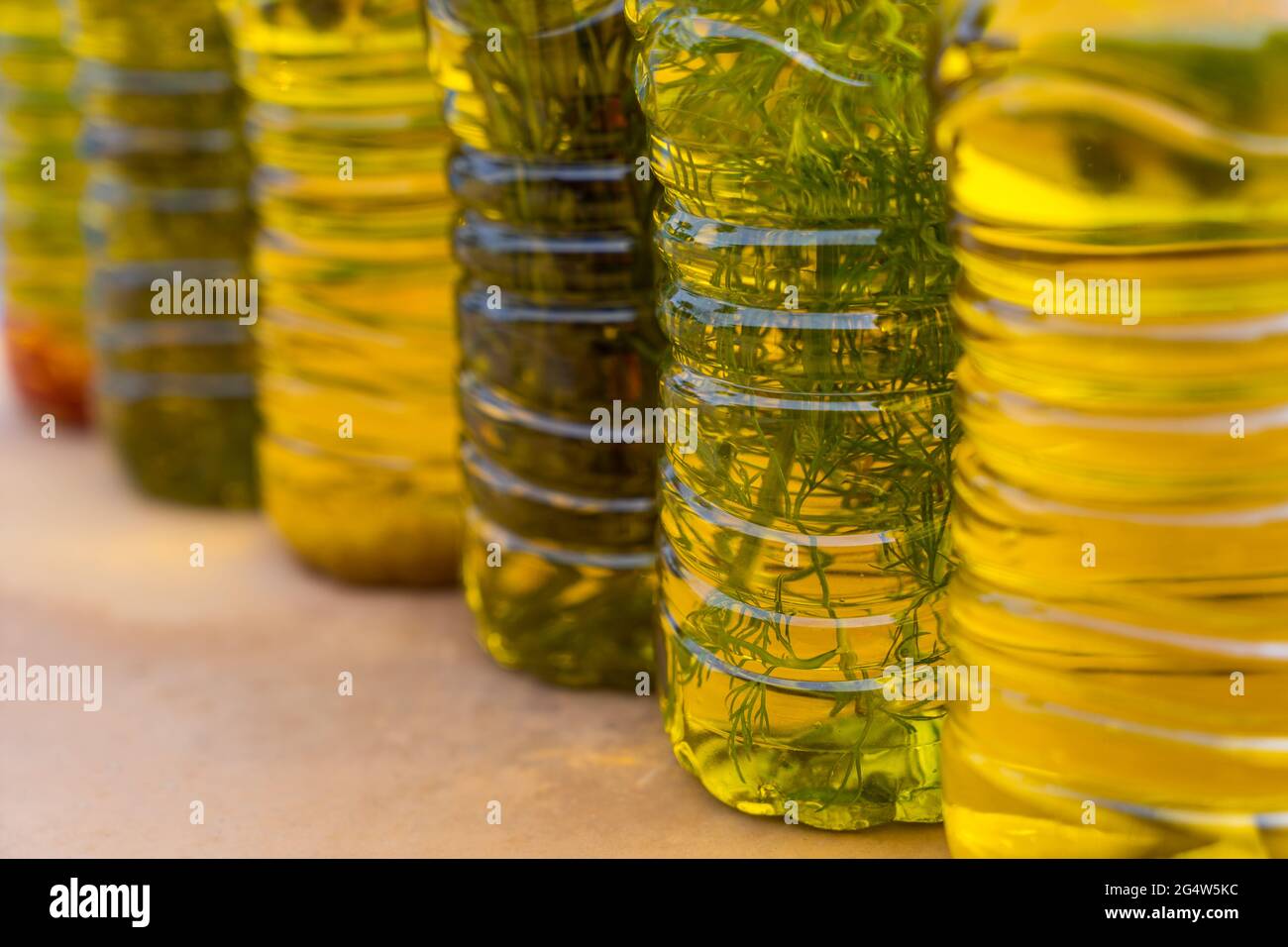 Serie von handgefertigten traditionellen kaltgepressten Olivenölen mit mediterranen Kräutern Stockfoto