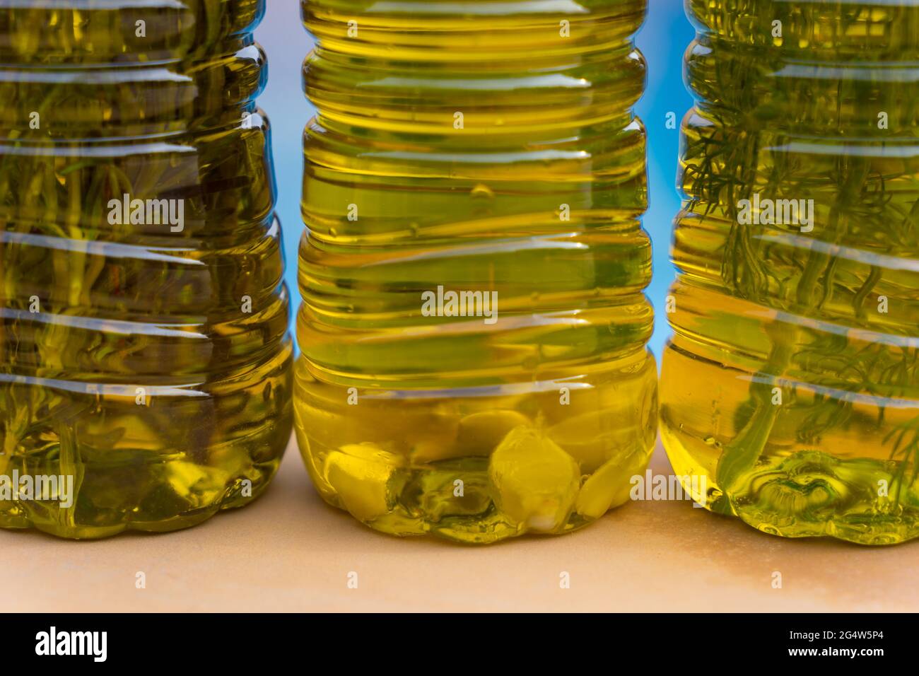 Auswahl an köstlichen natürlichen Olivenölen in verschiedenen Geschmacksrichtungen mit mediterranen Kräutern und Knoblauch Stockfoto