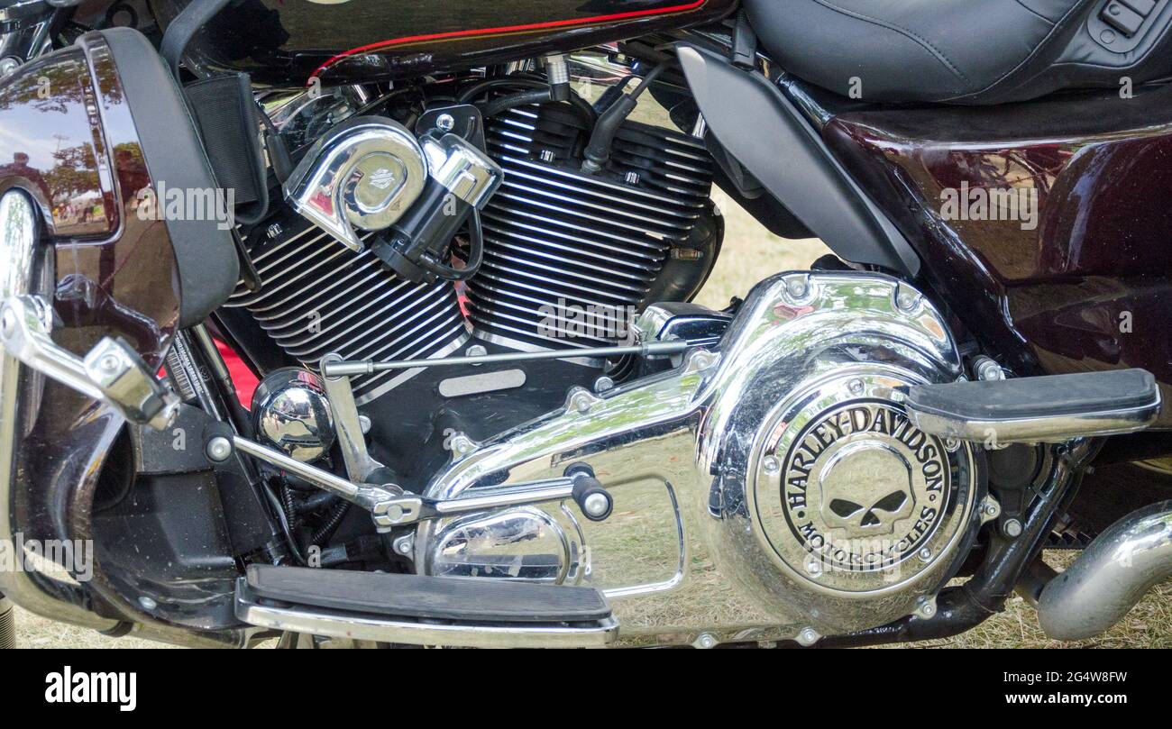 Teile eines Harley Davidson Motorrades sind in der Nahaufnahme zu sehen. Die glänzenden, polierten Chrom- und Stahlteile spiegeln die Bilder von nahe gelegenen Objekten und ein Stockfoto
