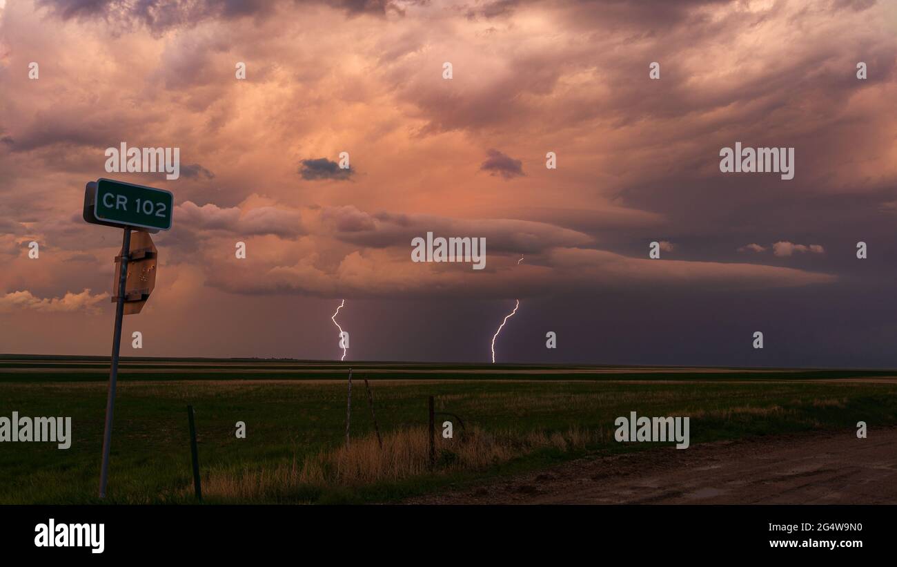 Mehrere Blitzschläge schlagen in der Ferne unter einem dunklen und bedrohlichen Himmel ab, während ein Gewitter durch den Osten Colorados zieht Stockfoto