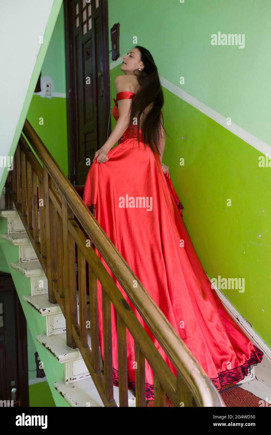 Frau in rotem Kleid auf der Treppe Stockfoto