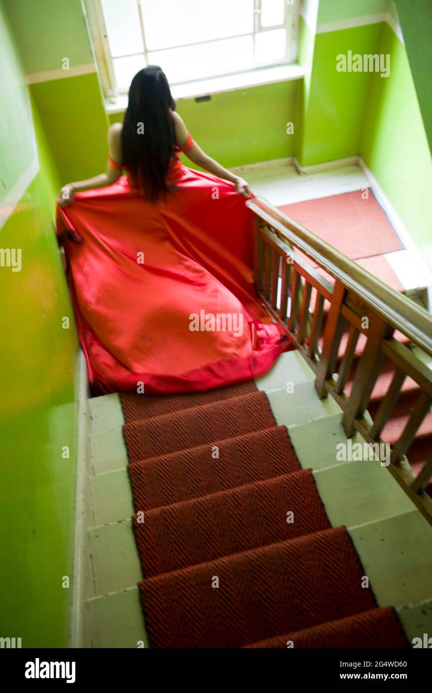 Frau in rotem Kleid auf der Treppe Stockfoto