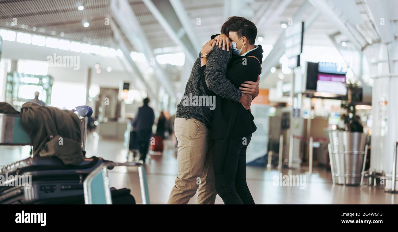 Treffen und Umarmen von Paaren am Flughafen. Mann und Frau treffen sich bei der Ankunft am Flughafen. Stockfoto