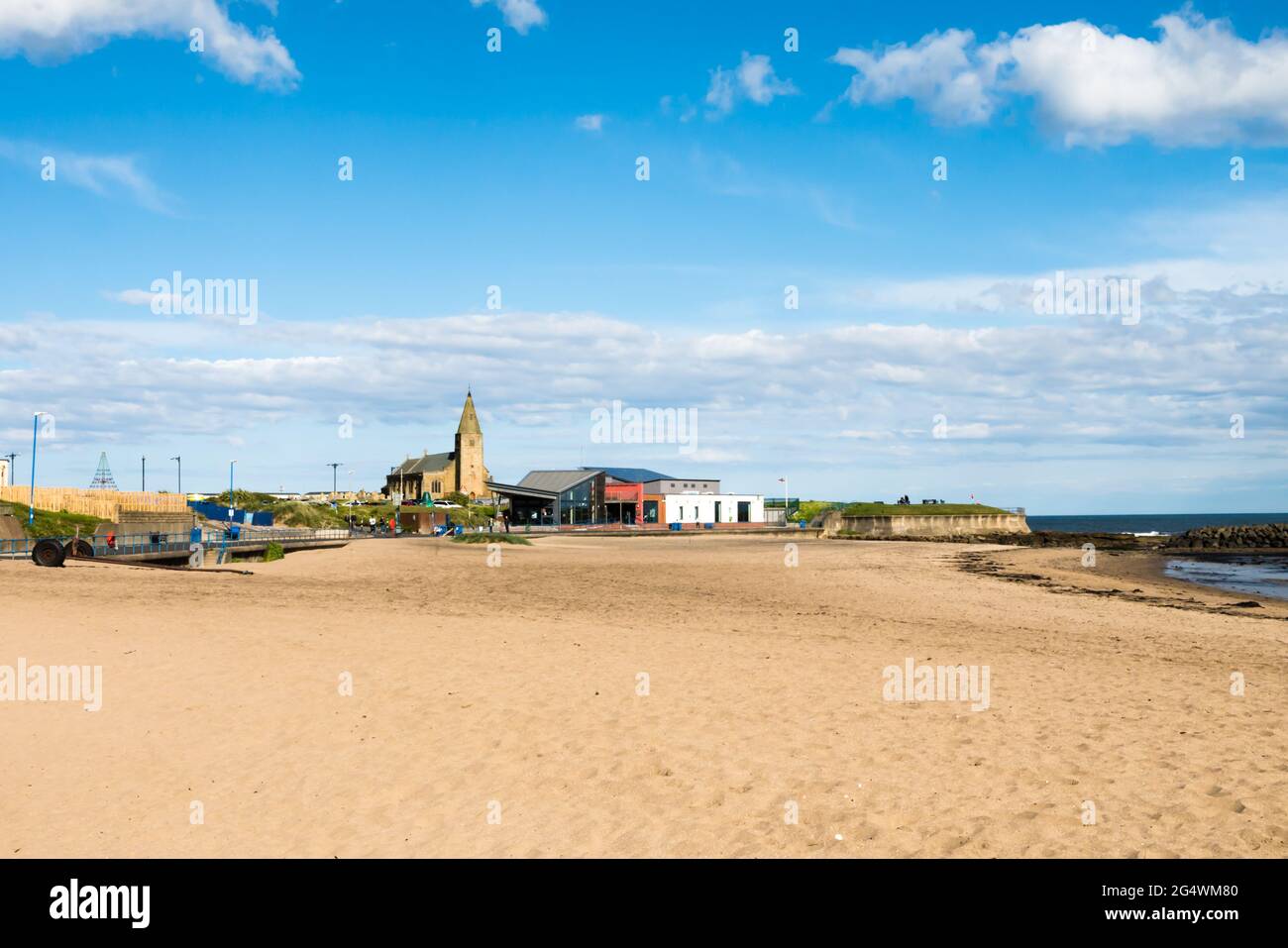 Blick auf Newbiggin-by-the-Sea Beach und Golden Sands mit Blick auf die Saint Bartholomews Church und das Newbiggin Maritime Center Stockfoto