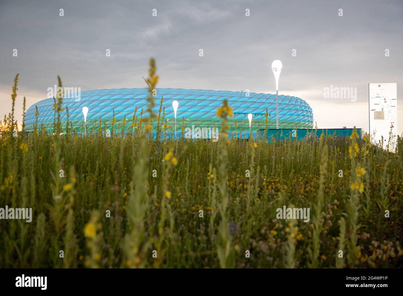 Allianz Arena leuchten blau und grün. LGBTQ Aktivist*innen teilen am 23. Juni 2021 in München an die ankommenden Fans Regenbögen Fähnchen. Anlass war, dass die UEFA im Vorfeld verboten hatte, dass die Allianz Arena während des Spiels Deutschland gegen Ungarn in Regenbogen Farben leuchtet. * Allianz Arena leuchtet blau und grün. LGBTQ-Aktivisten übergeben am 23. Juni 2021 Regenbogenfahnen an Fans in München. Die UEFA hat es verboten, die Allianz Arena während des Euro 2020-Spiels Deutschland gegen Ungarn in Regenbogenfarben erstrahlen zu lassen. (Foto: Alexander Pohl/Sipa USA) Quelle: SIPA USA/Alamy Live News Stockfoto