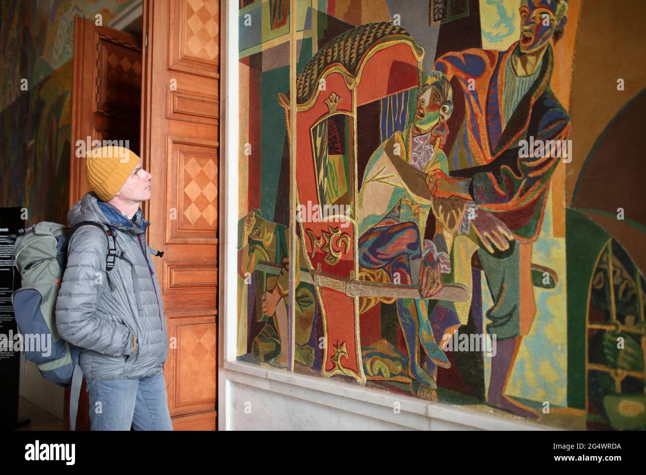 Tourist, der sich das Wandgemälde im Rathaus von Oslo, Oslo, Norwegen, ansieht Stockfoto