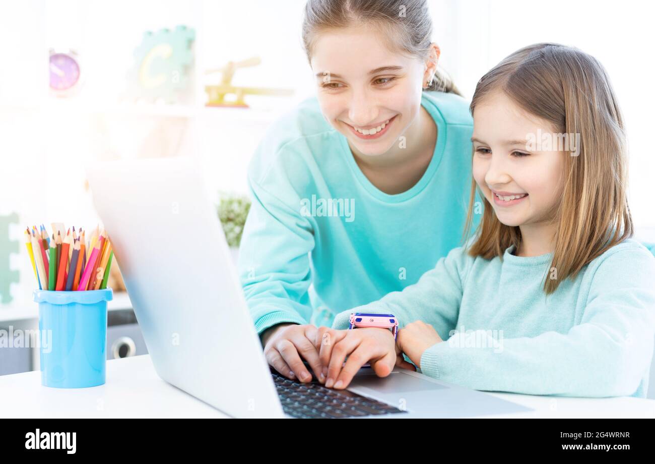 Glückliche Mädchen arbeiten am Computer in hellen Raum Stockfoto