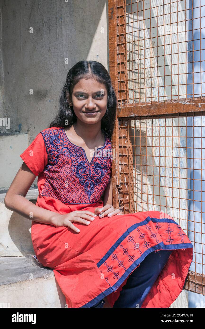 Ein ziemlich attraktiver indischer Teenager sitzt auf einer Stufe vor dem Haus, Trichy, Tamil Nadu, Indien Stockfoto