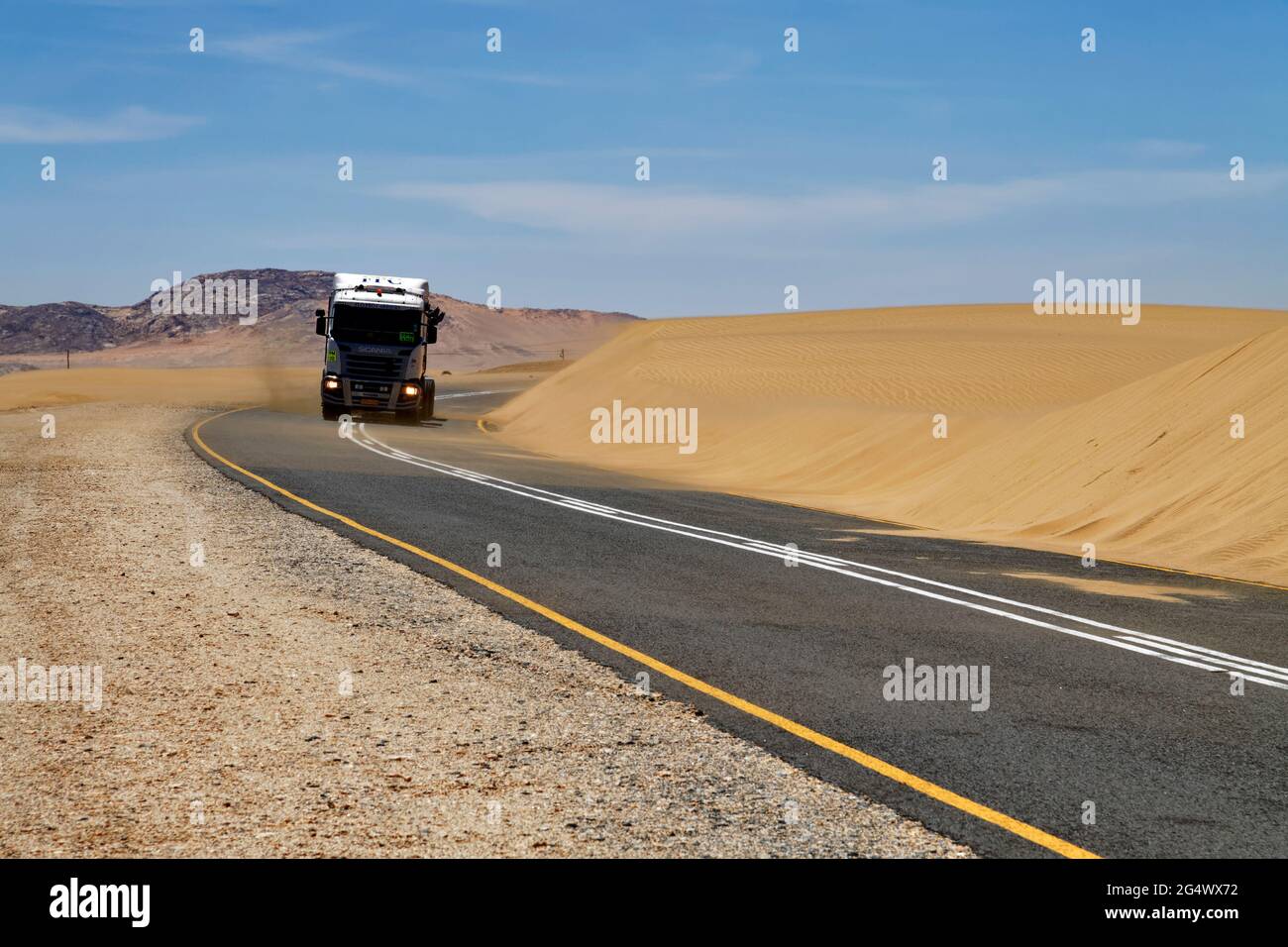 LKW auf Teerstraße B4 bei Lüderitz, Straße am Rande einer Düne in der Namib Wüste, Karas Region, Namibia Stockfoto