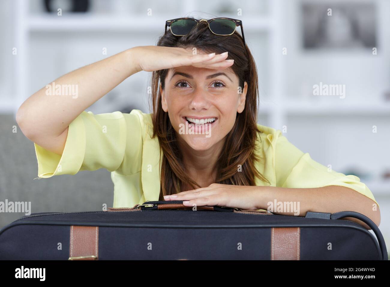Eine lustige Frau mit Koffer Stockfoto