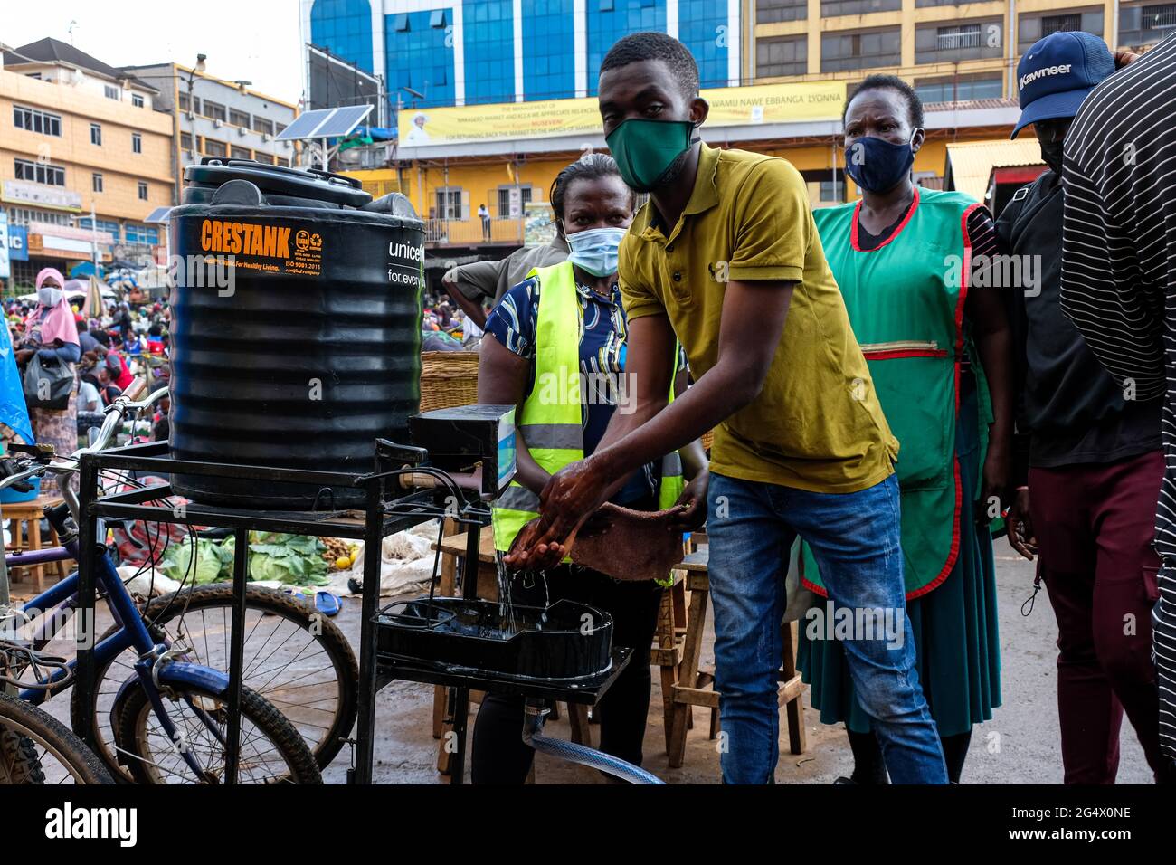 Kampala, Uganda. Juni 2021. Ein Mann wäscht sich die Hände, bevor er am 23. Juni 2021 in Kampala, Uganda, auf einen Markt kommt. Eine virulente zweite Welle von COVID-19 zerstört das Land mit einer positiven Rate von 17.1 Prozent weiter. Quelle: Hascharah Nalwadda/Xinhua/Alamy Live News Stockfoto