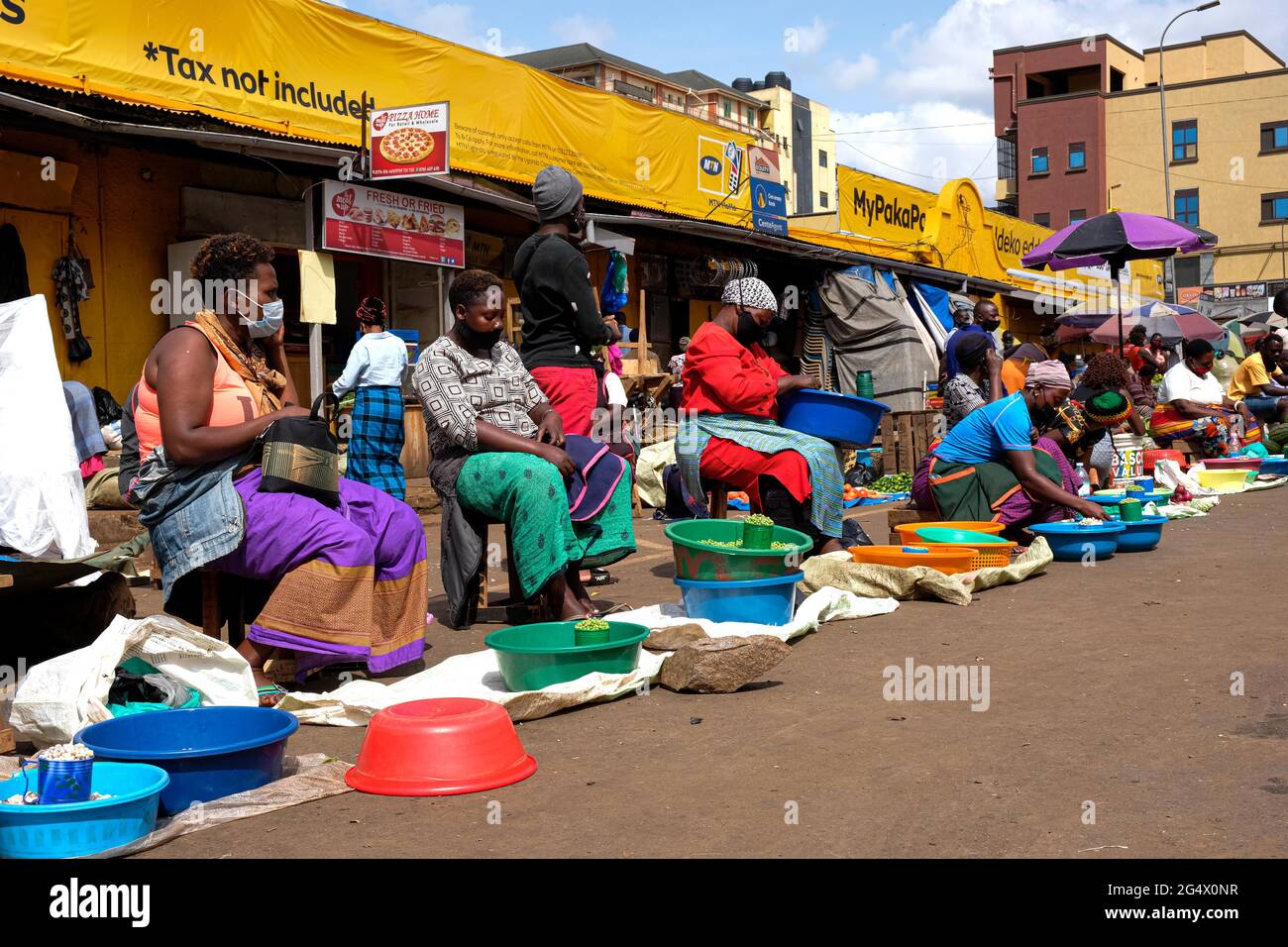 Kampala, Uganda. Juni 2021. Anbieter mit Gesichtsmasken verkaufen Gemüse auf einem Markt in Kampala, Uganda, am 23. Juni 2021. Eine virulente zweite Welle von COVID-19 zerstört das Land mit einer positiven Rate von 17.1 Prozent weiter. Quelle: Hascharah Nalwadda/Xinhua/Alamy Live News Stockfoto