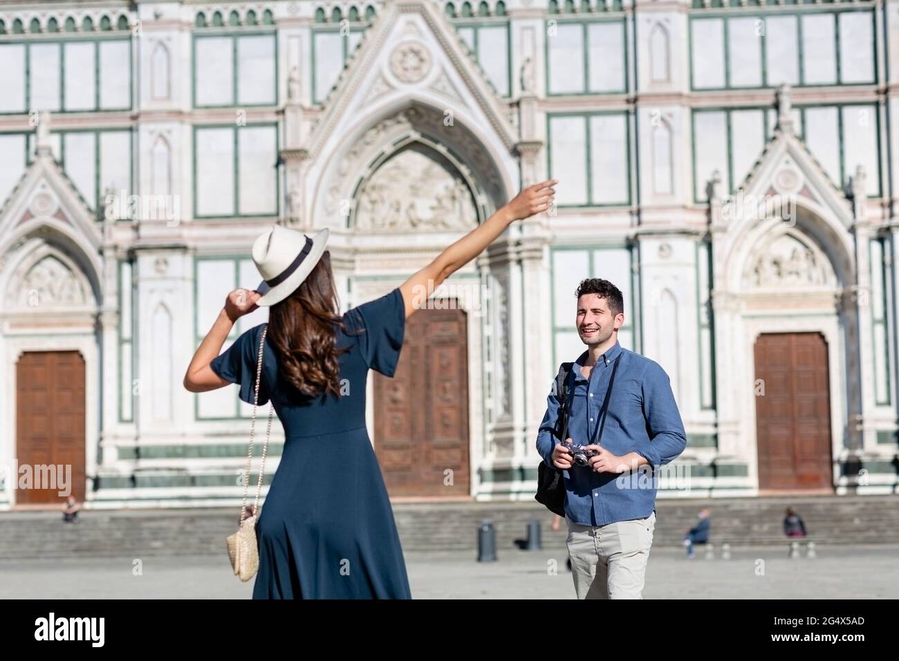 Weibliche Touristen, die mit einem Mann auf der Piazza Di Santa Croce, Florenz, Italien, stehen Stockfoto