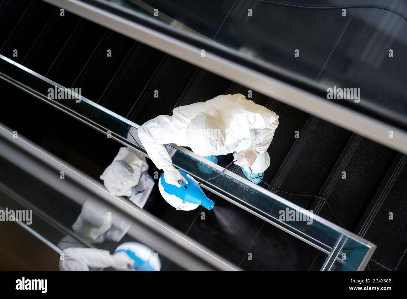 Sanitäter dekontaminieren Bürotreppe mit Desinfektion Stockfoto