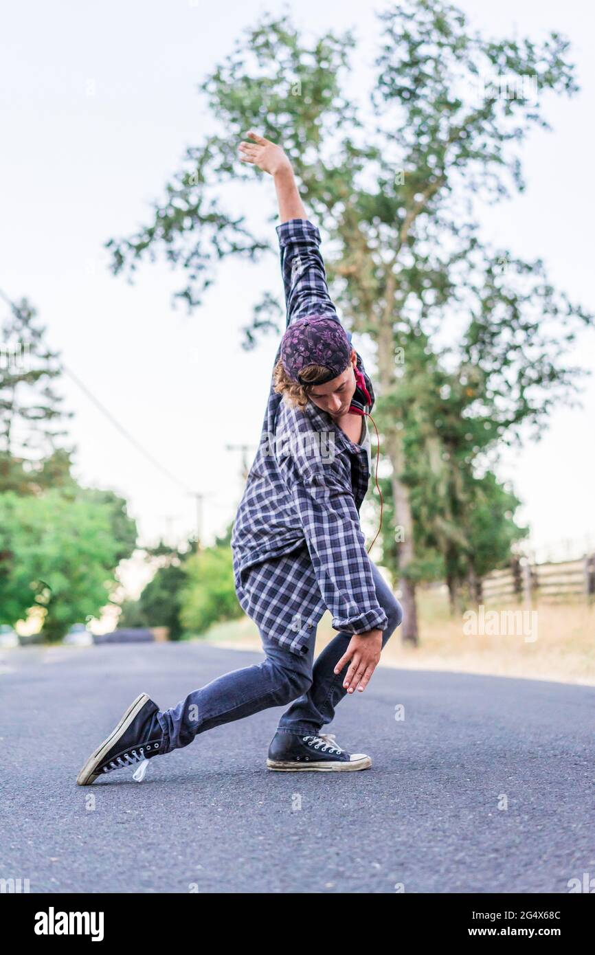 Junger Mann im karierten Hemd tanzt auf der Straße Stockfoto