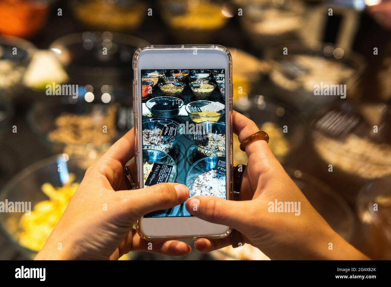 Junge Frau fotografiert Lebensmittel im Supermarkt Stockfoto