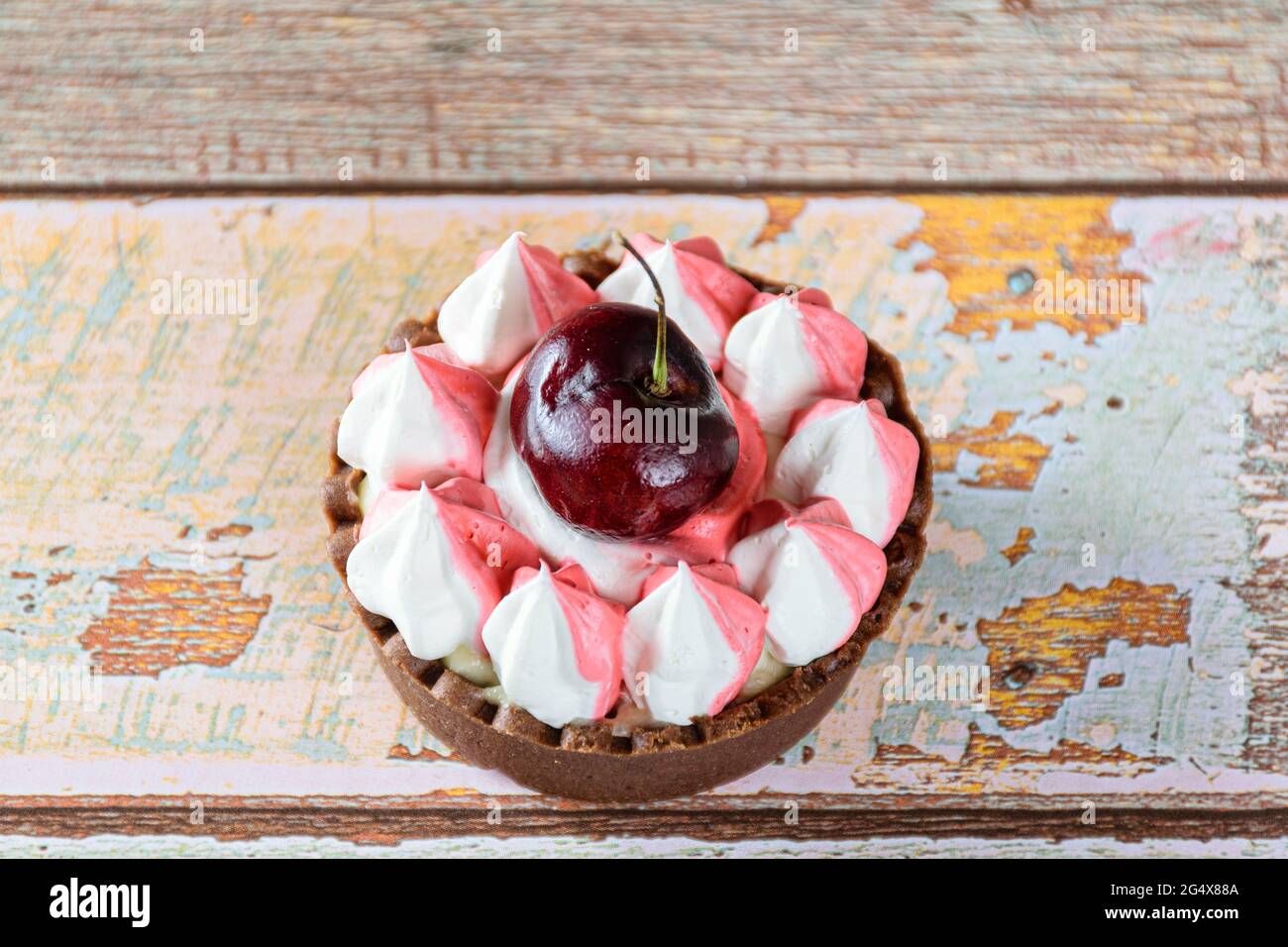 Schokoladen-Mini-Pie-Nahaufnahme mit Schokoladenganache, Schlagsahne und Kirschtoping. Stockfoto