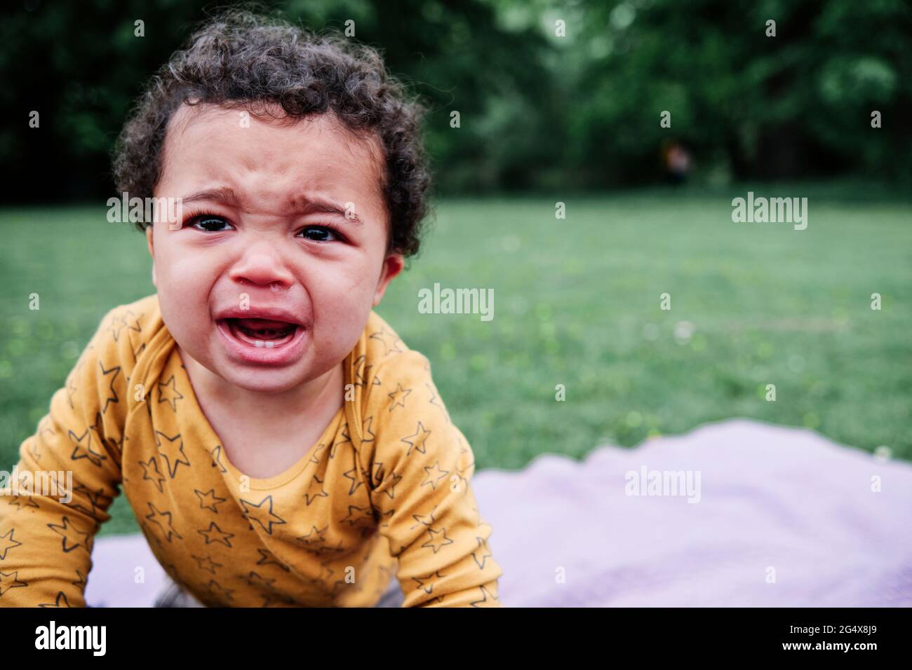 Netter kleiner Junge, der im Park weint Stockfoto