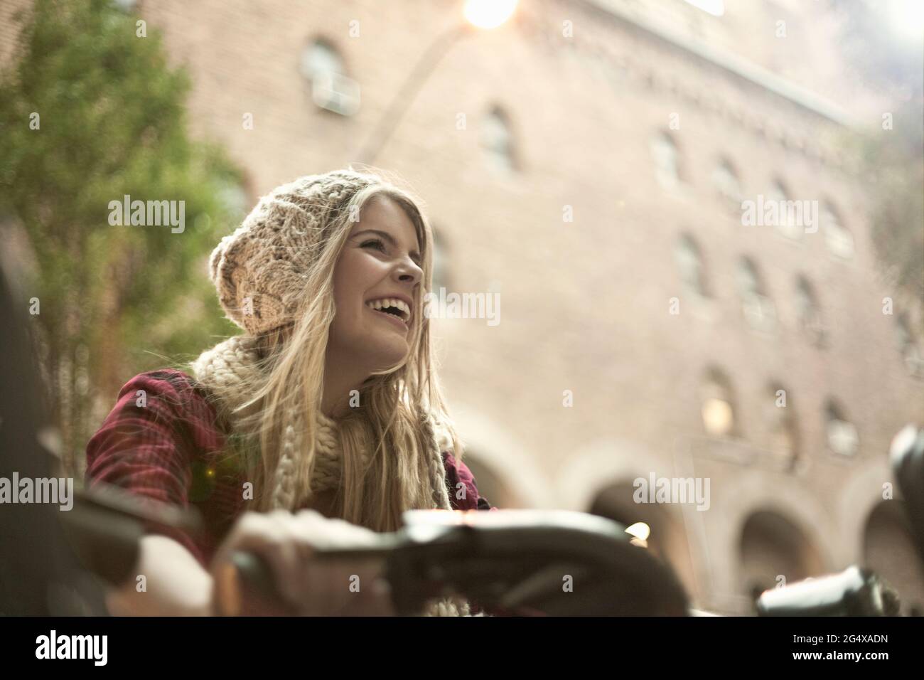 Fröhliche junge Frau beim Radfahren in der Stadt Stockfoto