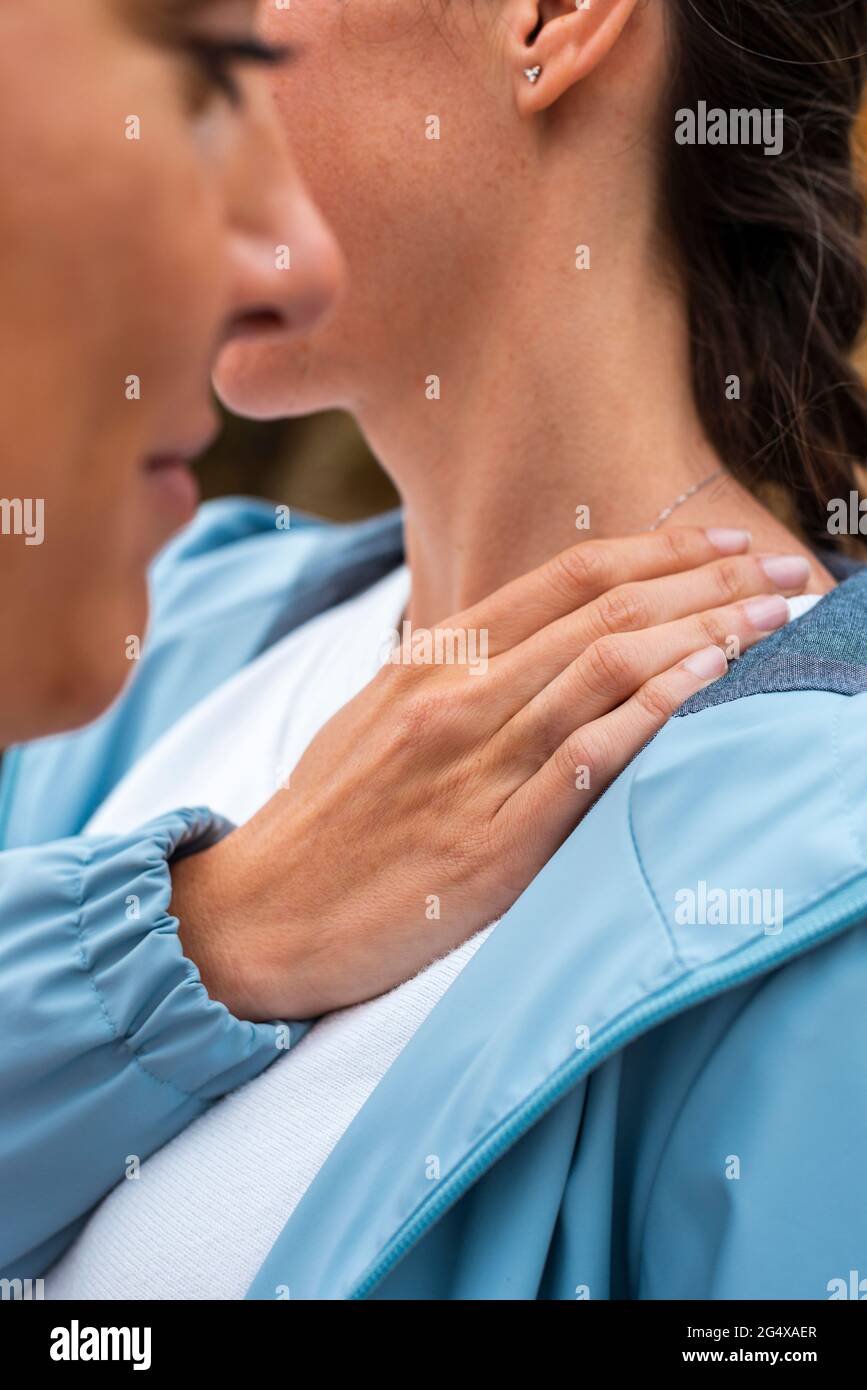 Frau mittleren Erwachsenen mit der Hand auf der Schulter Stockfoto