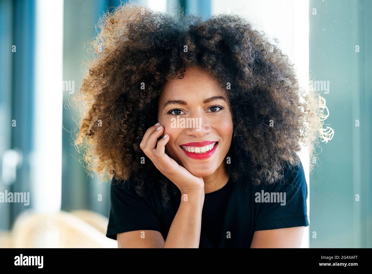 Lächelnde Geschäftsfrau mit Afro-Haaren im Büro Stockfoto