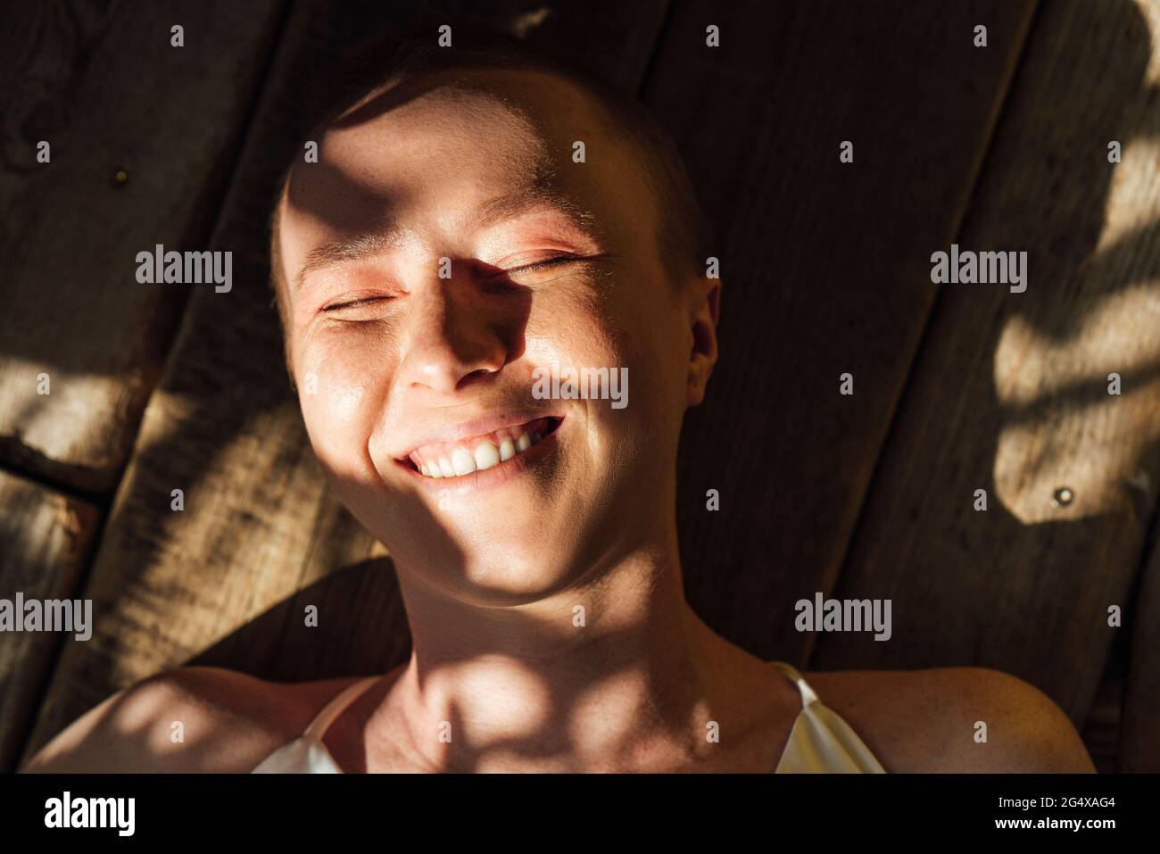 Sonnenlicht auf dem Gesicht einer glücklichen jungen Frau Stockfoto