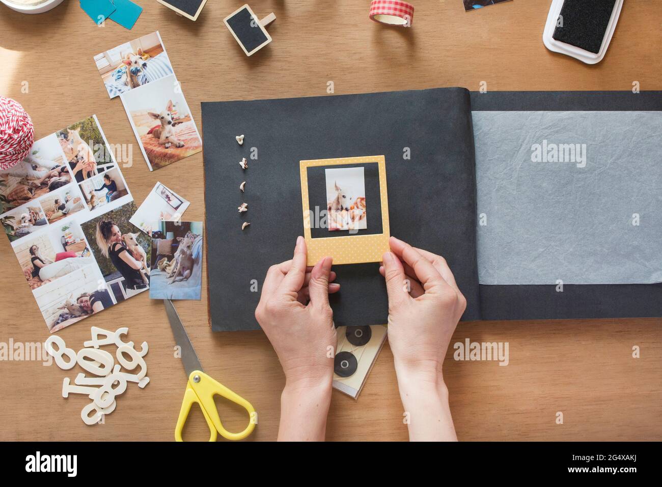 Frau kleben Rahmen über Hund Foto in Scrapbook Stockfoto