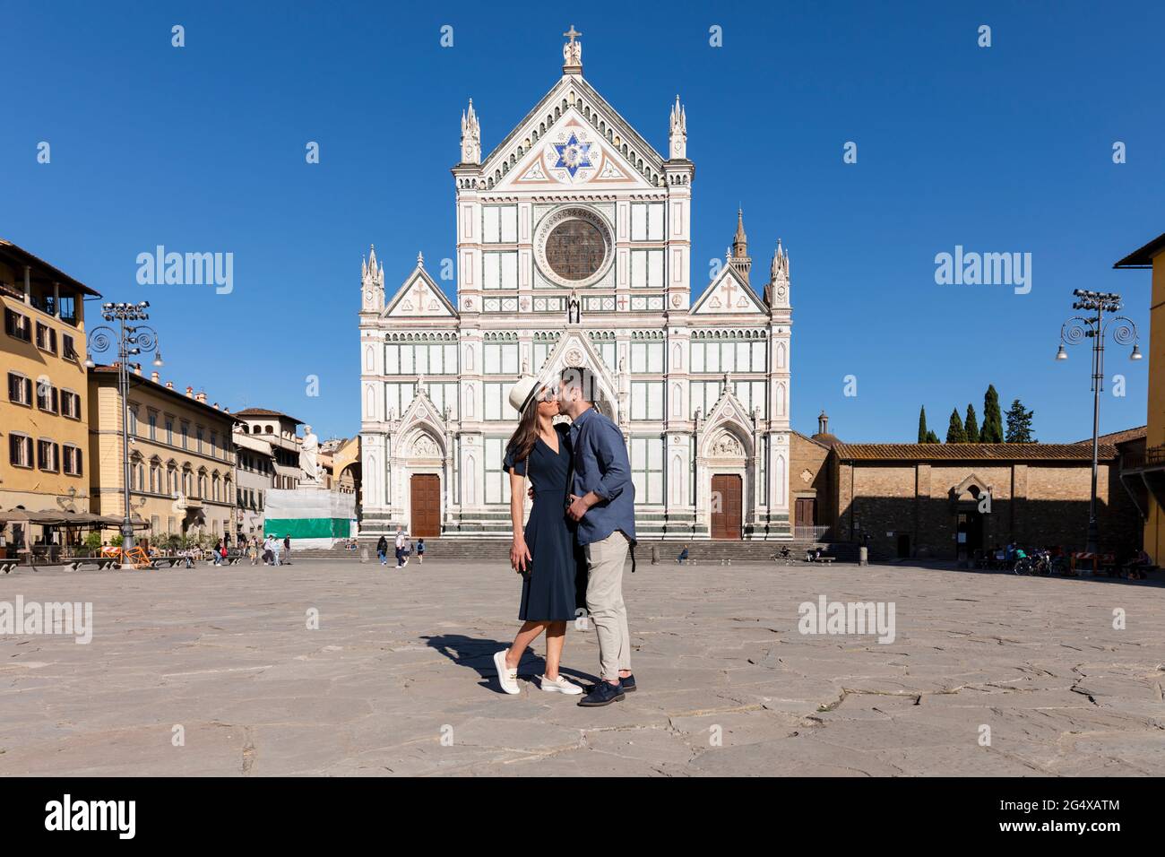 Das Paar küsst sich gegenseitig, während es auf der Piazza Di Santa Croce, Florenz, Italien, steht Stockfoto