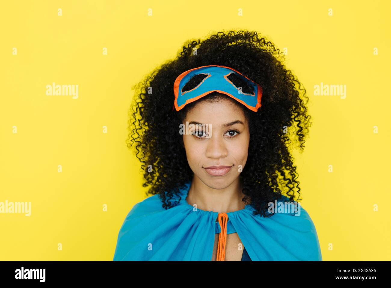Afro-Frau im Superhelden-Kostüm auf gelbem Hintergrund Stockfoto