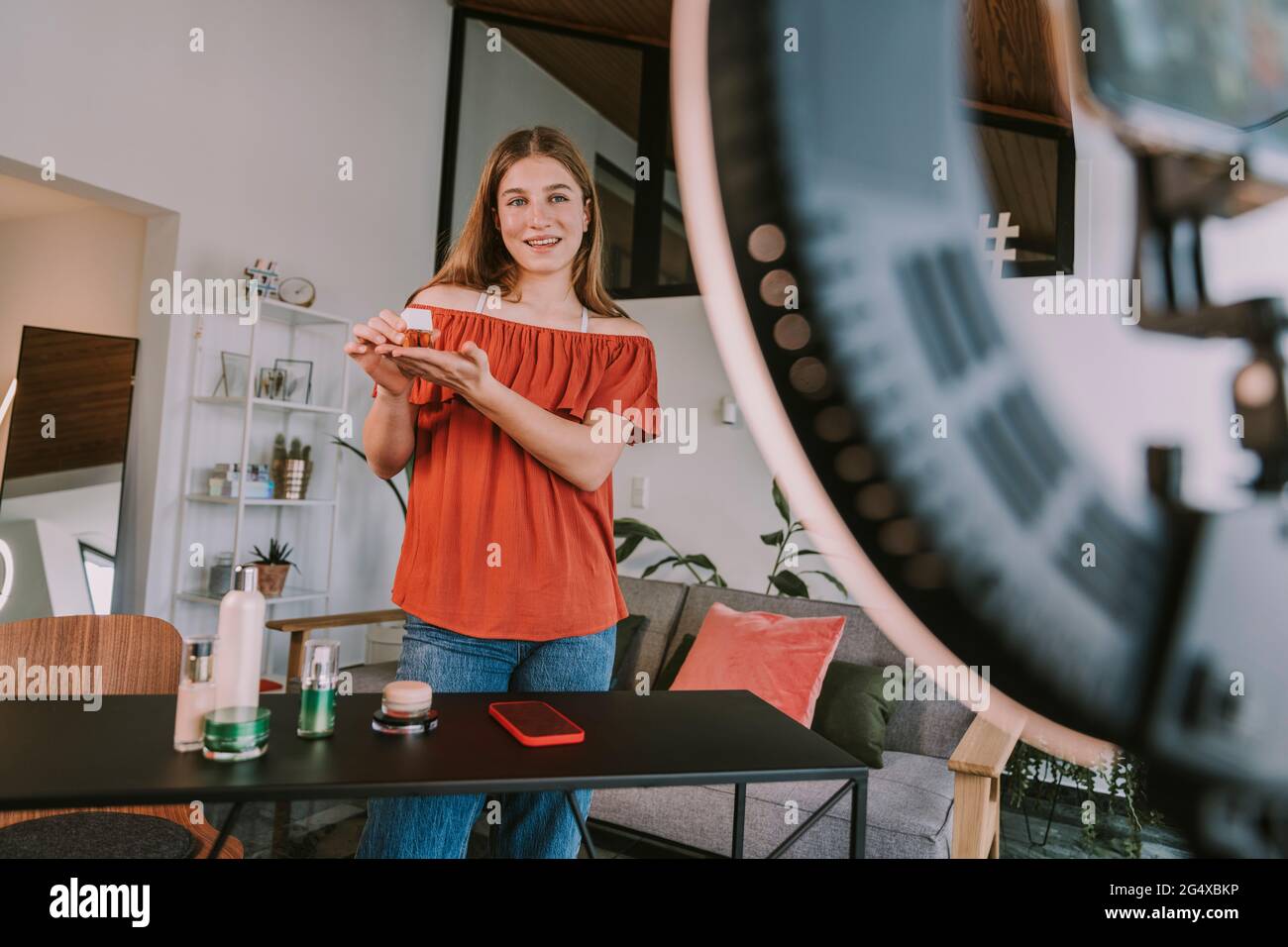 Weibliche Influencerin präsentiert Nagellack während des Vlogging beim Workshop Stockfoto