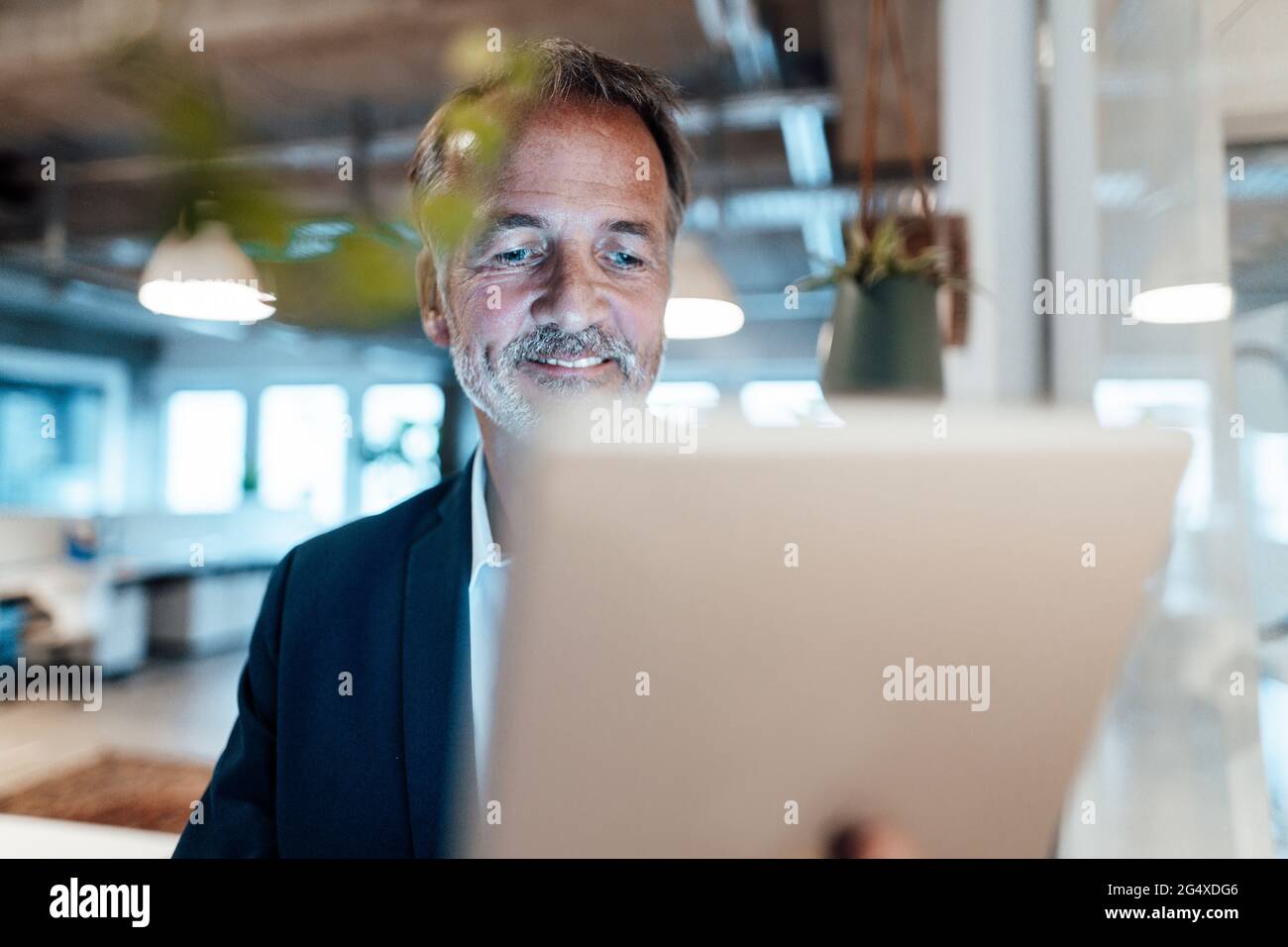 Leitender männlicher Unternehmer, der im Büro digital eingesetzt wird Stockfoto