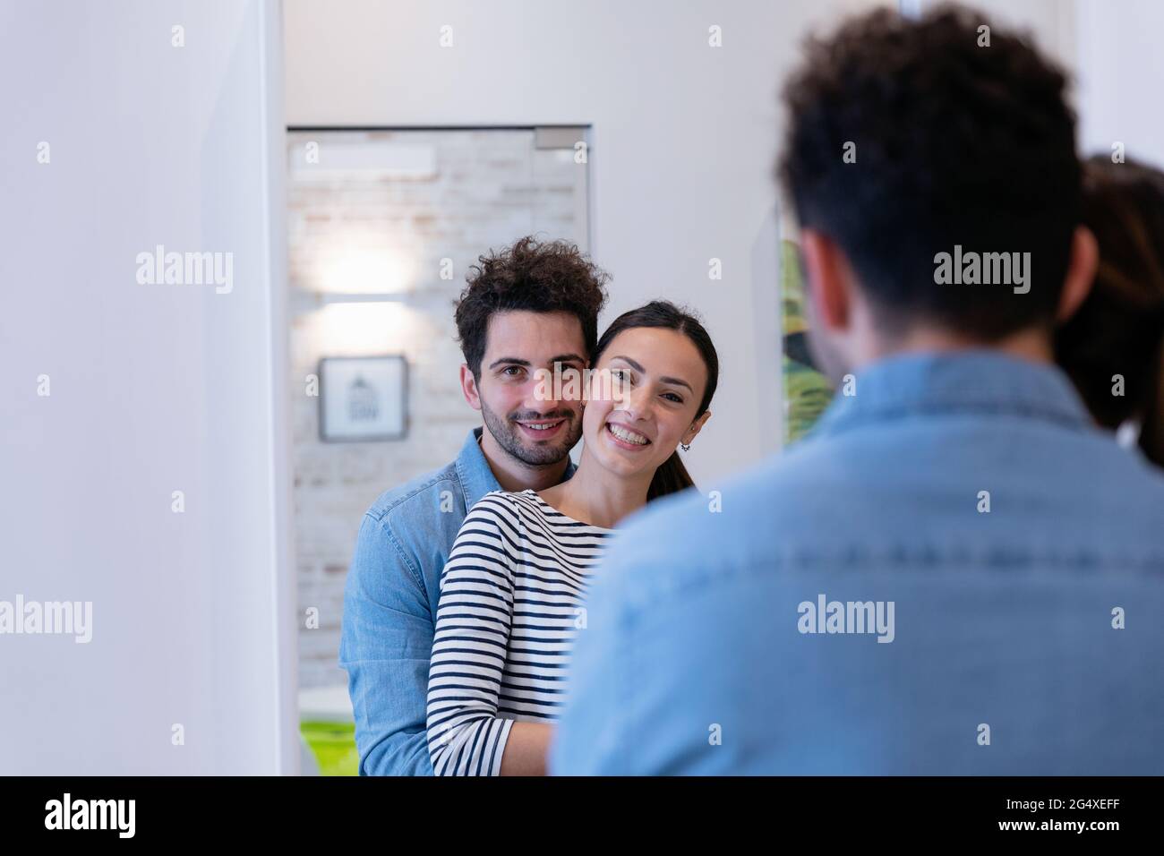 Nettes Paar umarmt vor dem Spiegel zu Hause Stockfoto