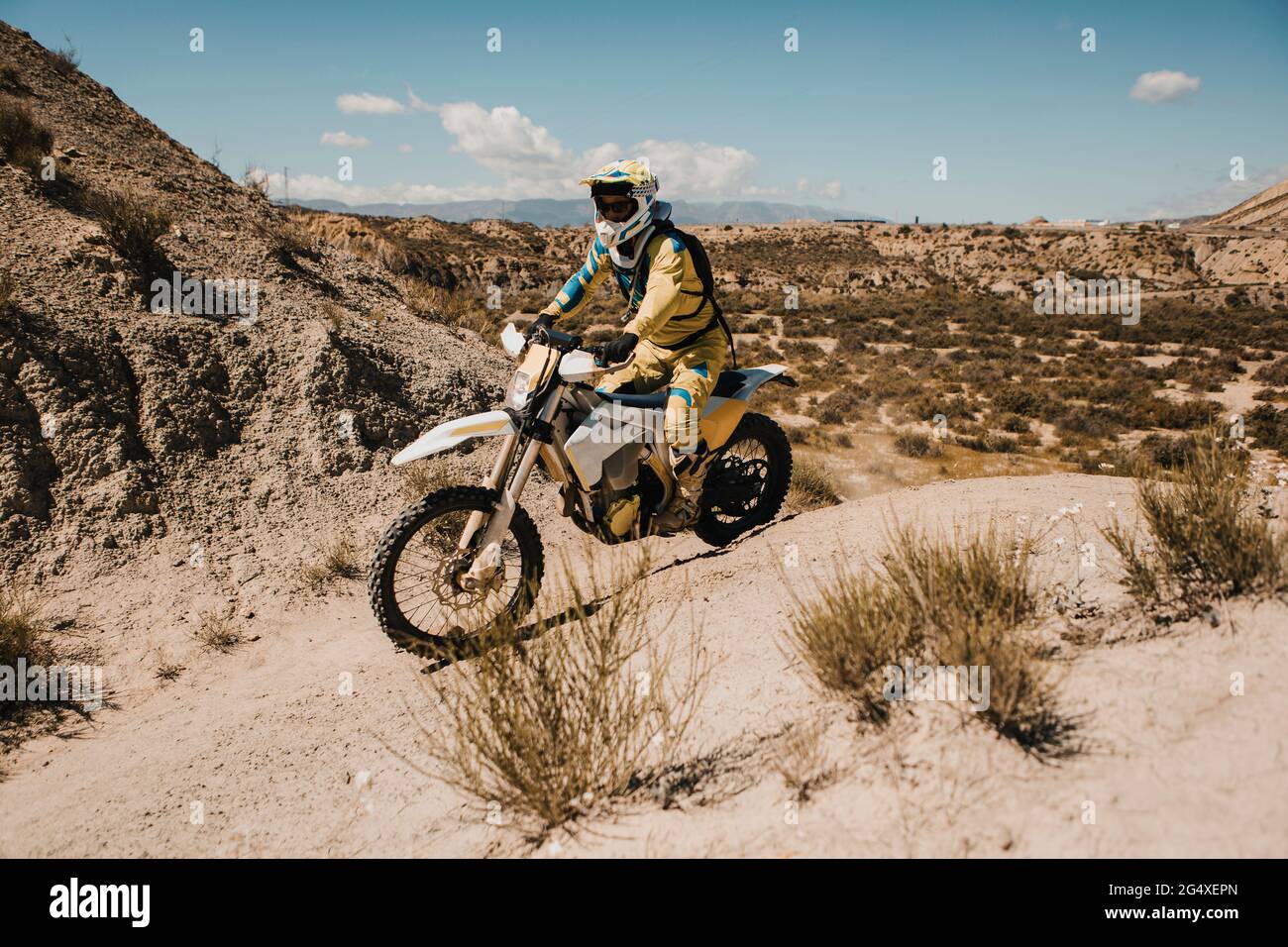 Männlicher Biker mit schützender Sportbekleidung fährt am sonnigen Tag Motorrad Stockfoto