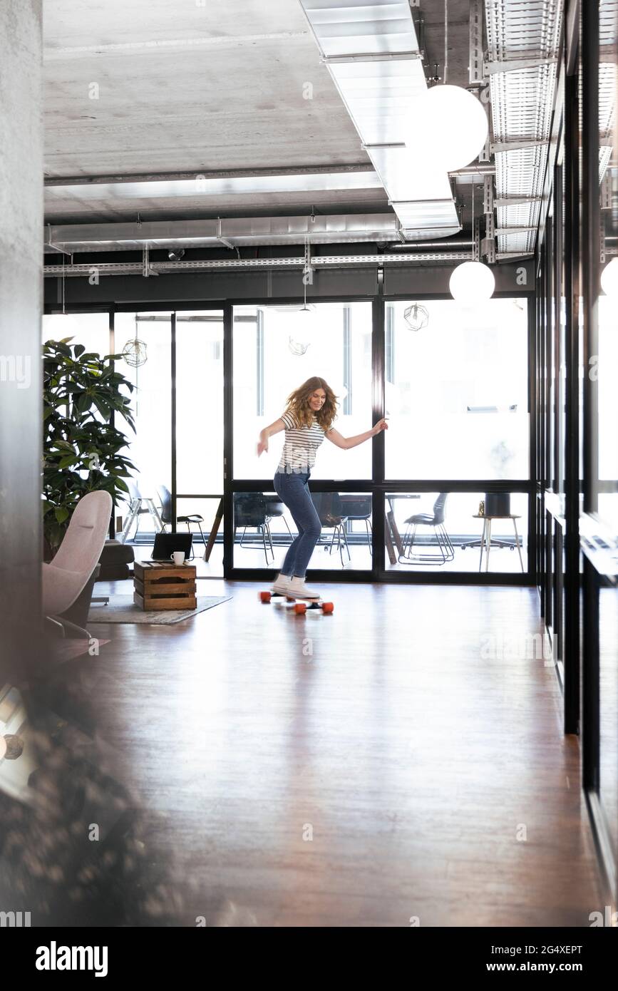 Geschäftsfrau Reiten Skateboard im Büro Stockfoto