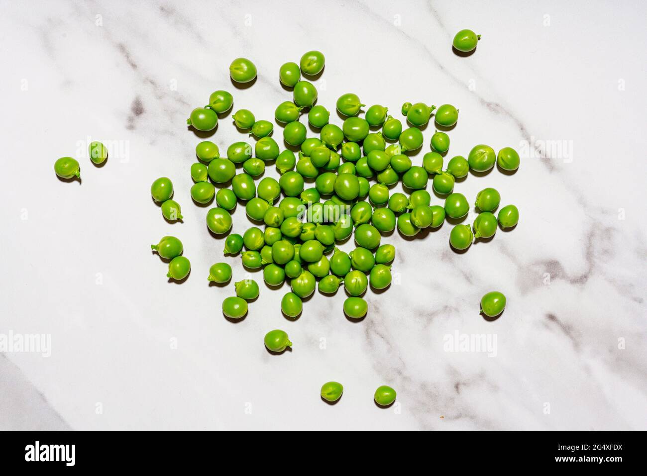 Rohe grüne Erbsen auf Marmoroberfläche Stockfoto