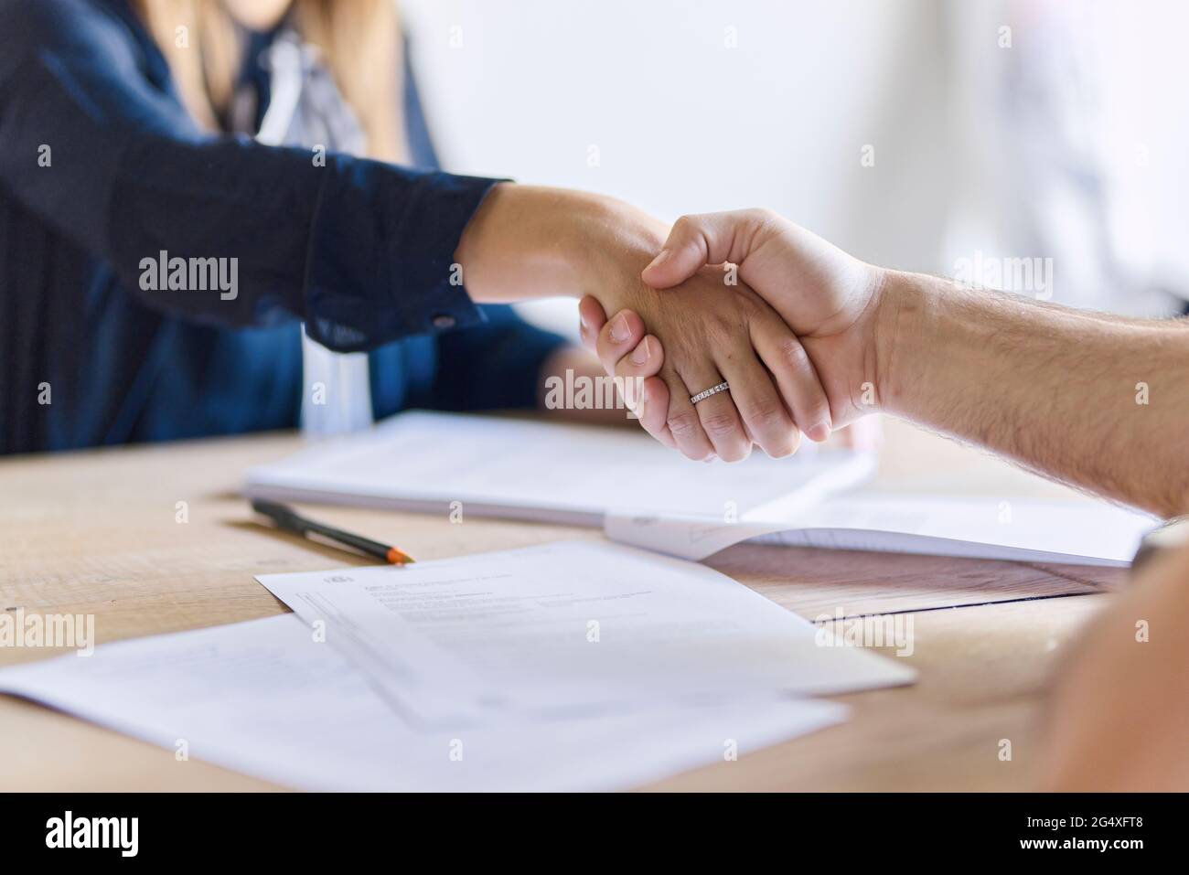 Reifer männlicher Kunde schüttelt sich die Hände mit Frau im Büro Stockfoto