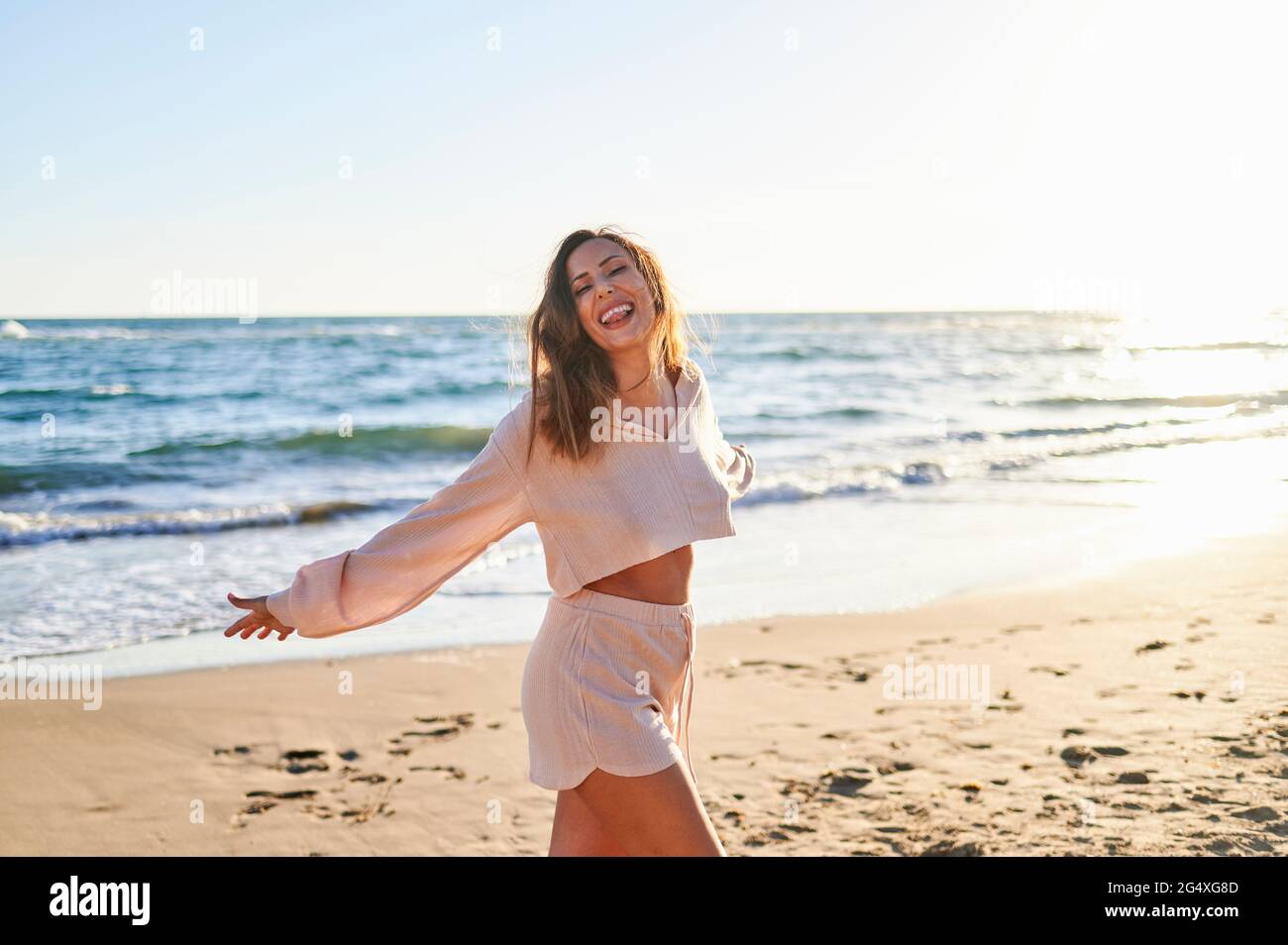 Frau in legerer Kleidung, die an sonnigen Tagen am Strand genießt Stockfoto
