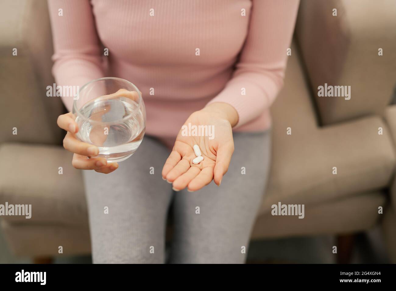 Nahaufnahme einer runden weißen Pille in der jungen weiblichen Hand Stockfoto