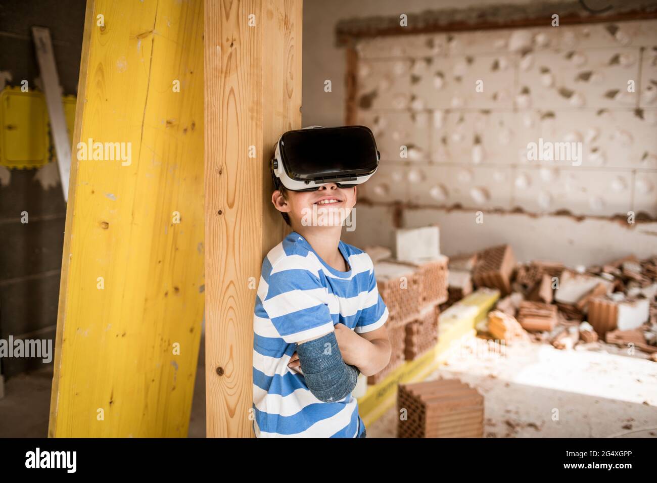 Junge mit gebrochenem Arm mit Virtual-Reality-Headset in der Loft-Wohnung Stockfoto