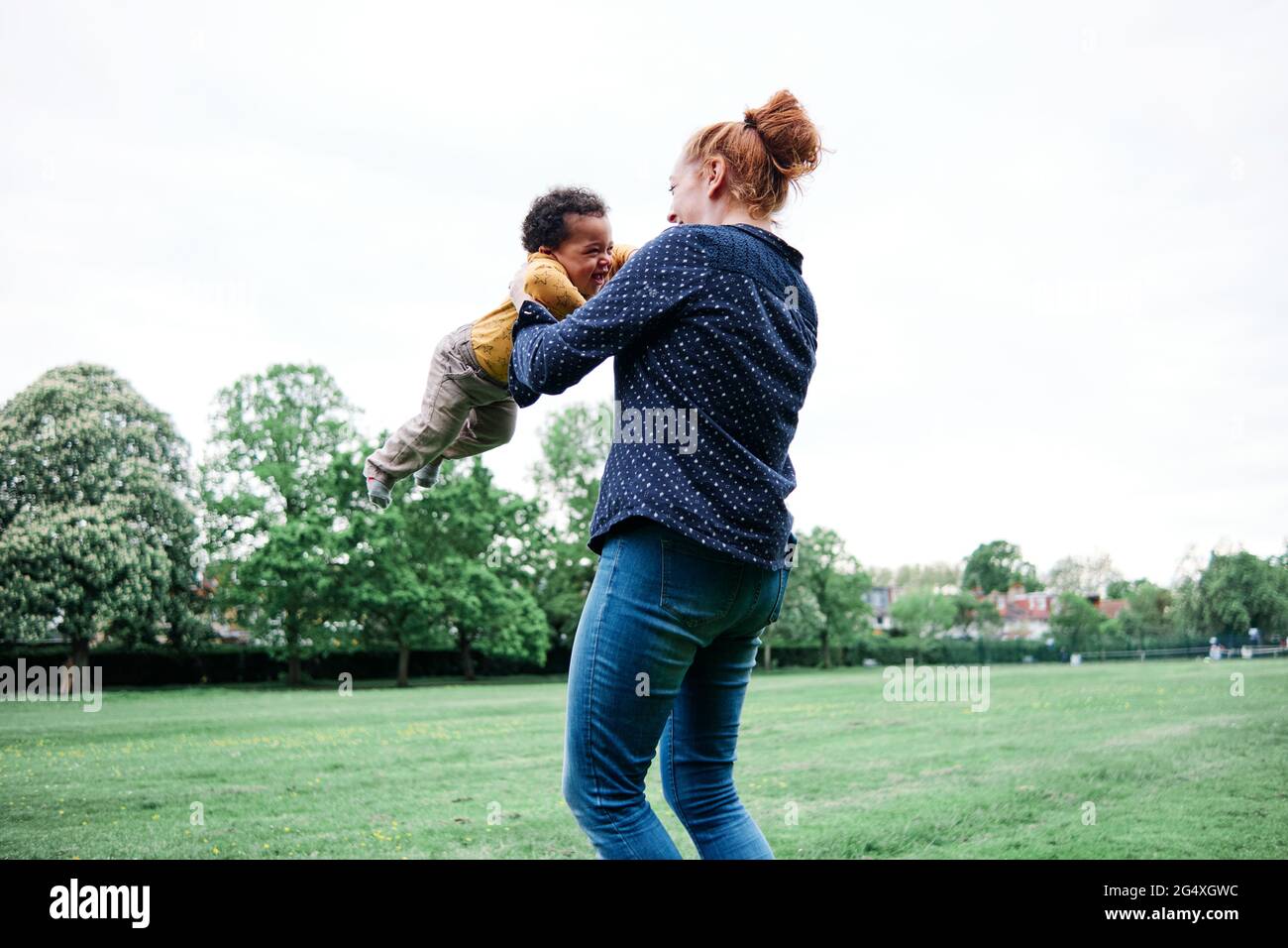 Glückliche Mutter, die mit dem Sohn im Park spielt Stockfoto