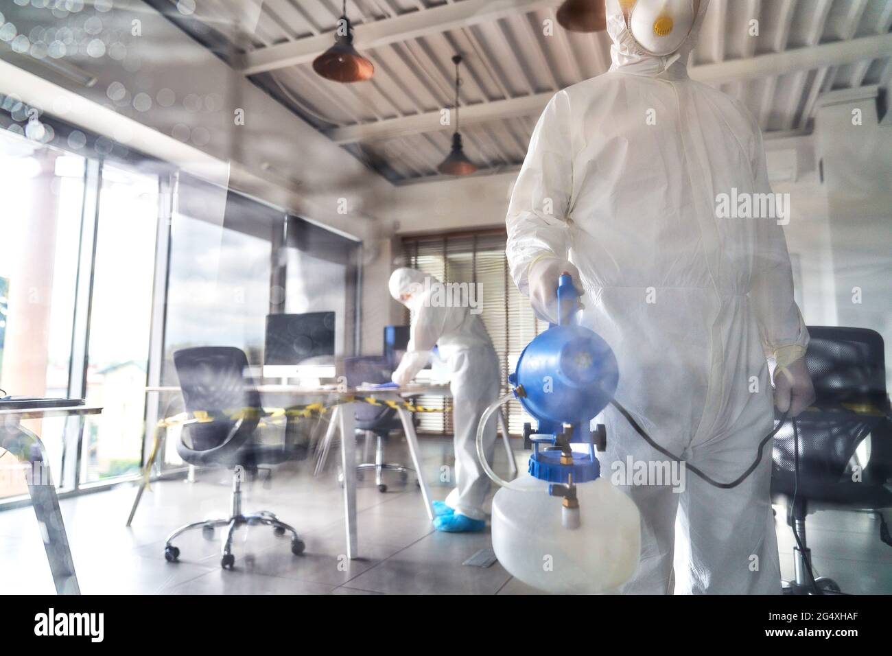 Sanitäter mit Reinigungsausrüstung im Büro Stockfoto