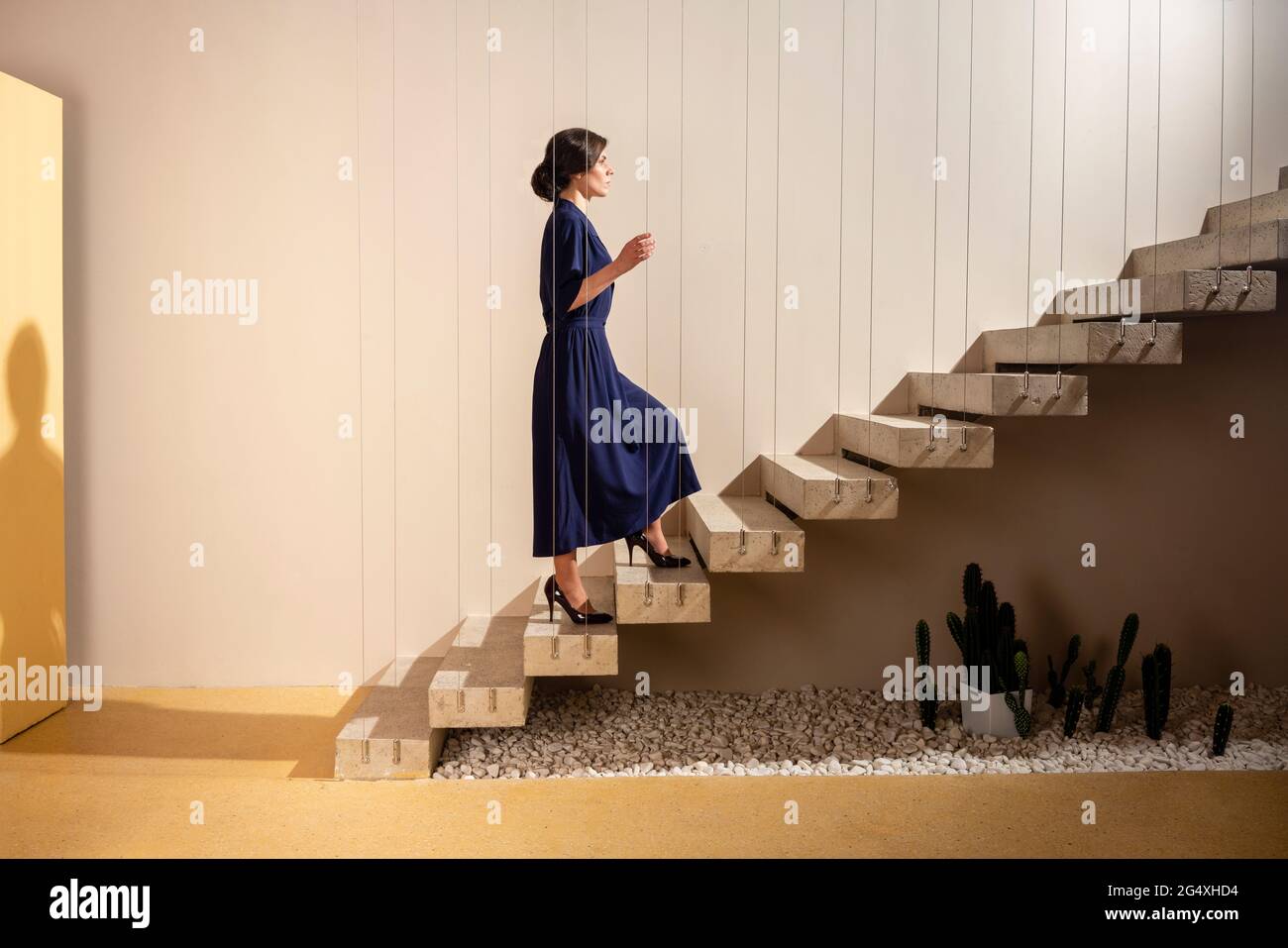 Junge Frau, die auf der Treppe aufsteht Stockfoto