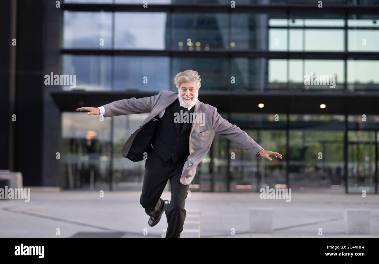 Fröhlicher Geschäftsmann vor dem Bürogebäude Stockfoto