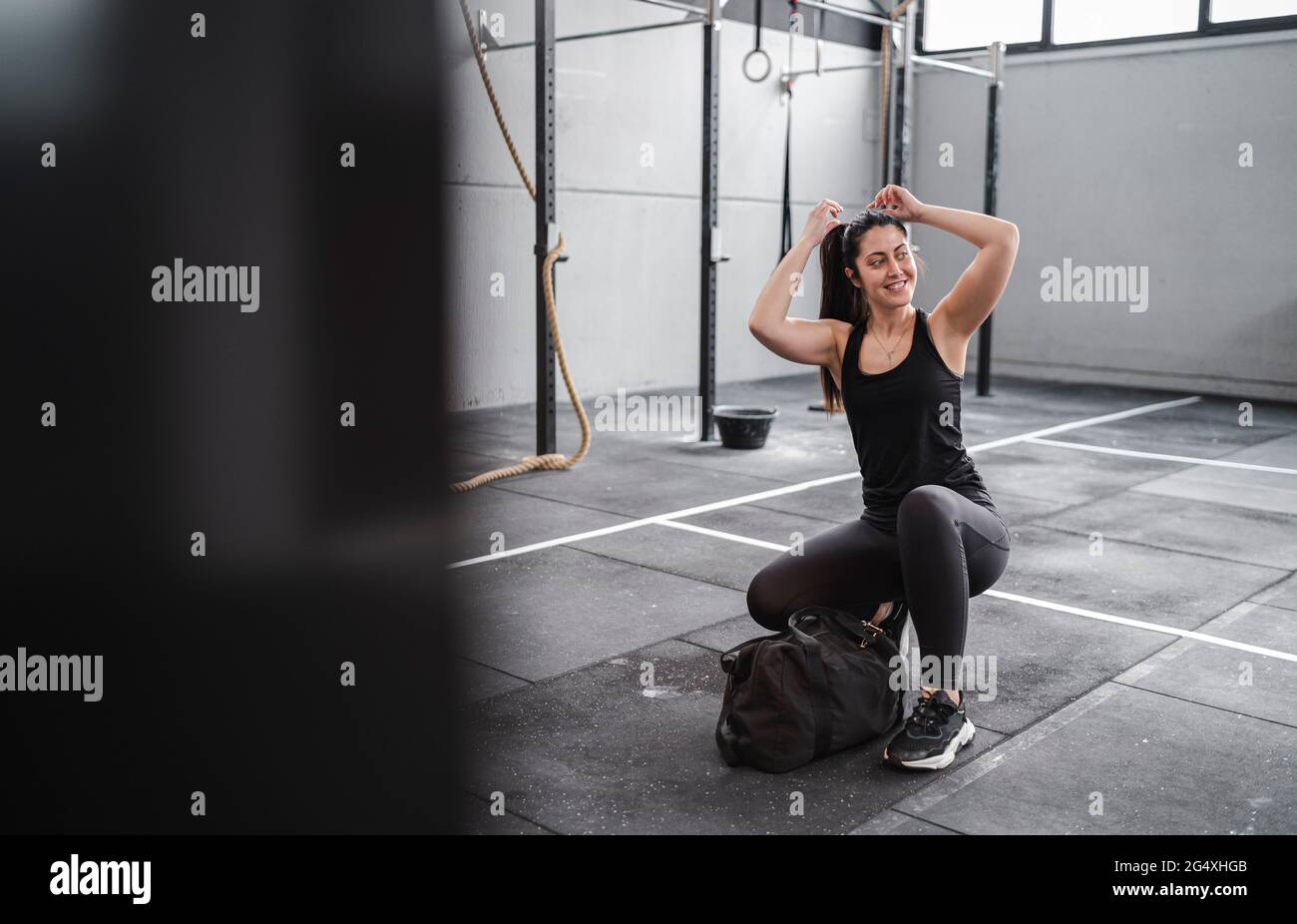 Lächelnde Frau, die sich für das Training im Fitnessstudio vorbereitet Stockfoto